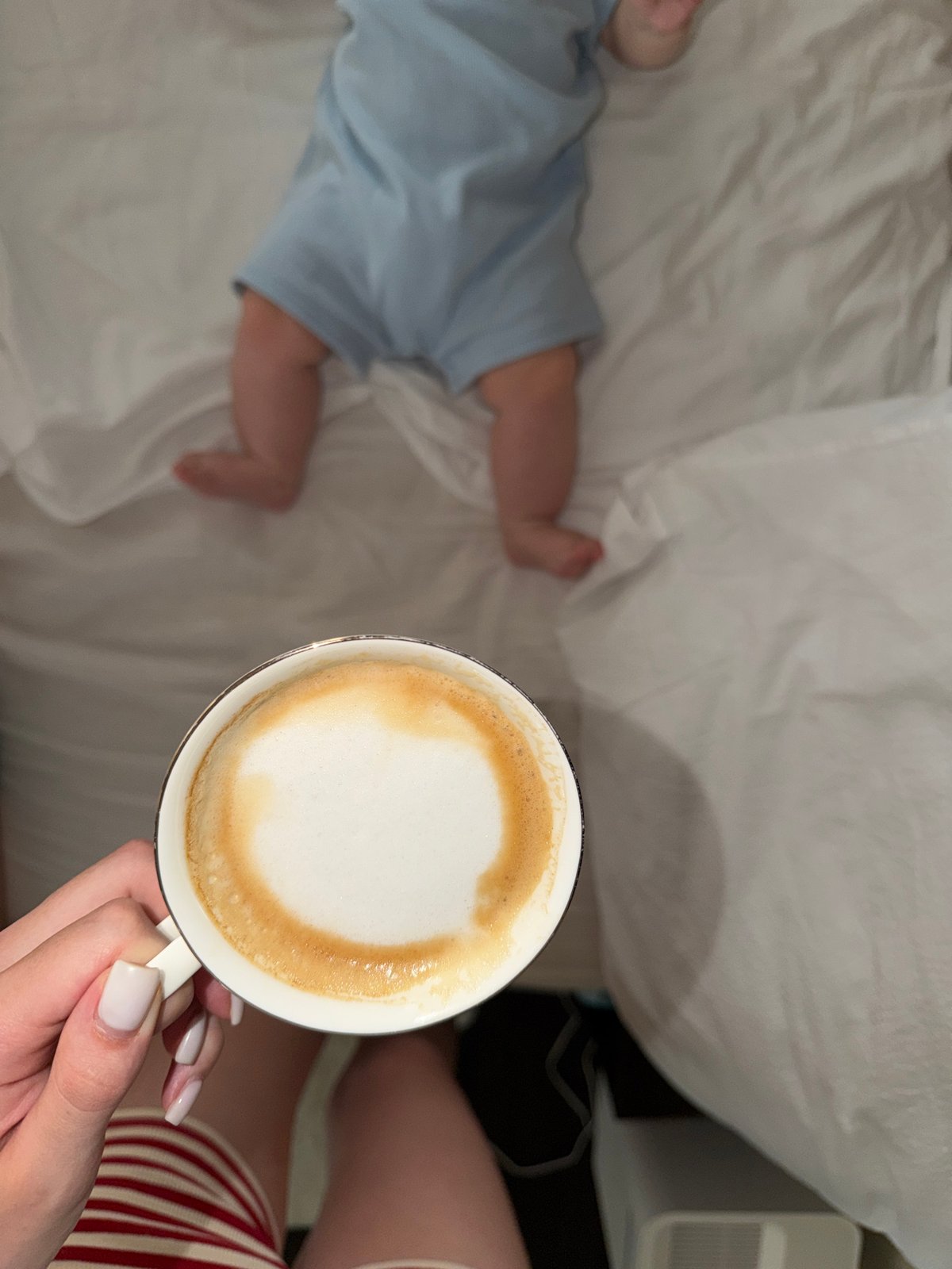 Early morning moment: baby rests as adult enjoys coffee