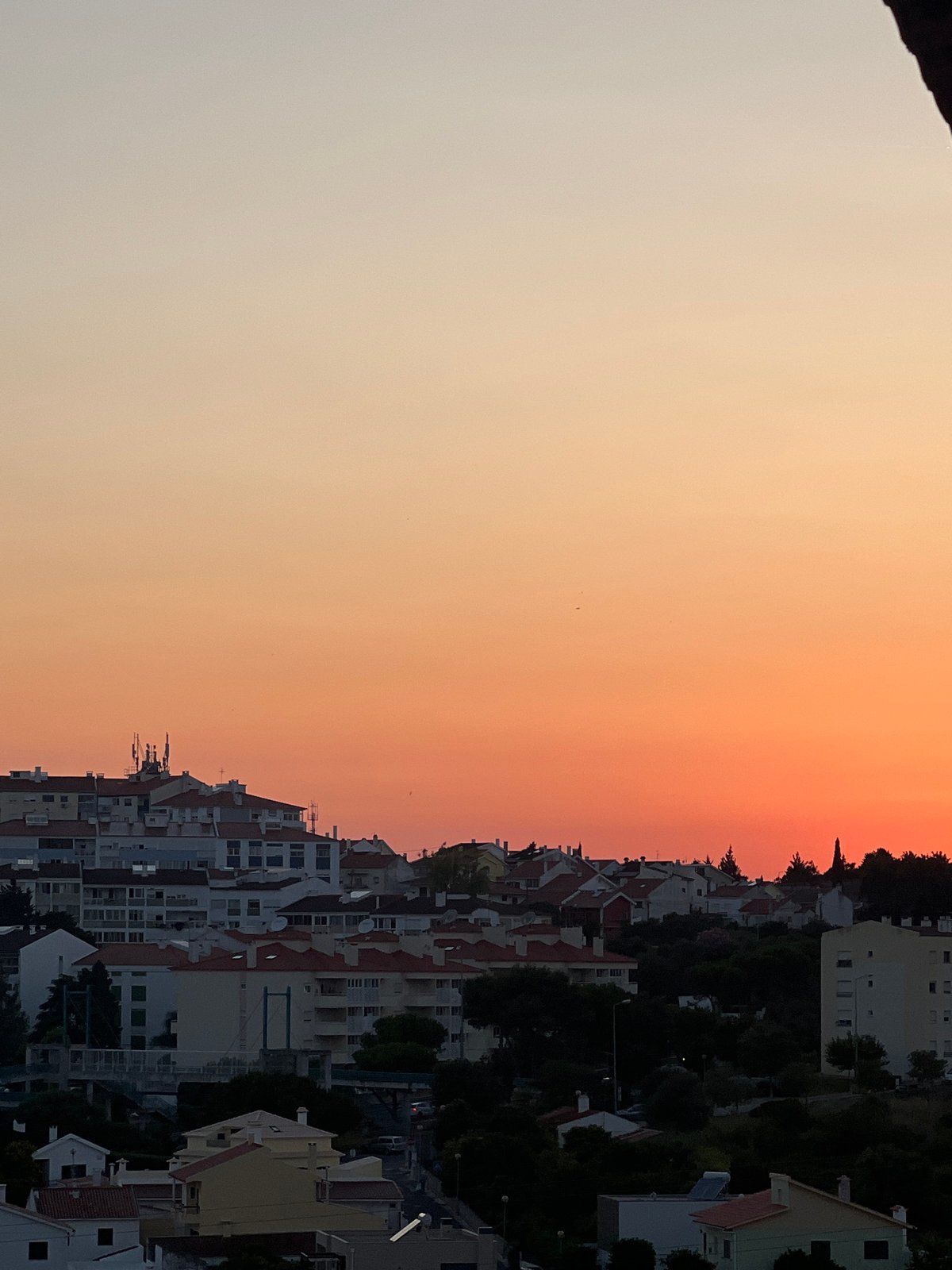 Cascais rooftops glow under a vivid summer sunset