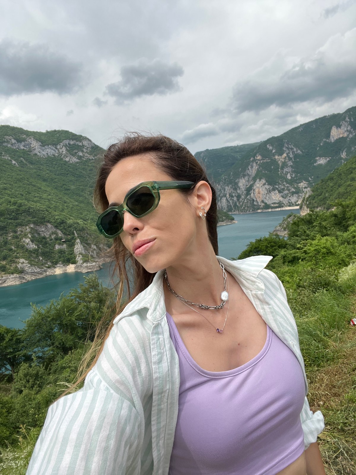 Woman photographs scenic mountain lake vista in Plužine, Montenegro