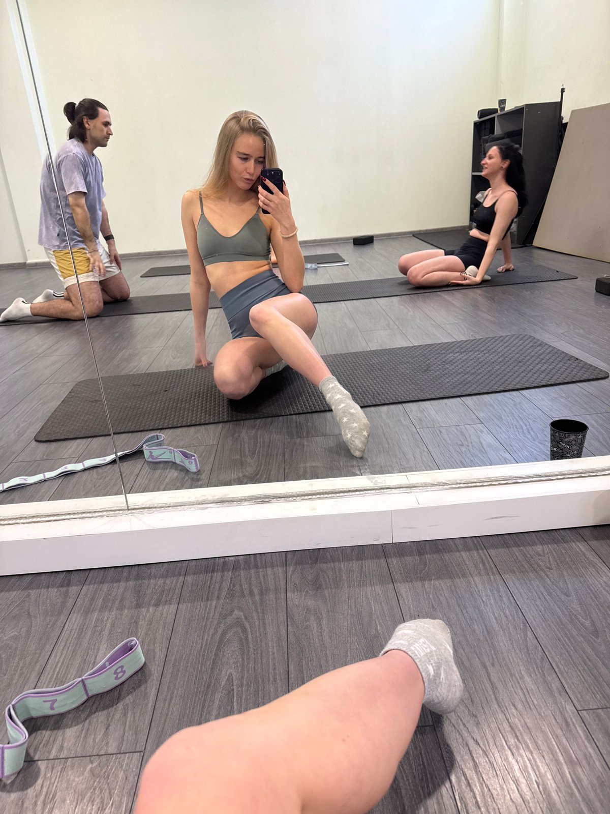 Yoga class participants practice poses, document session with selfies