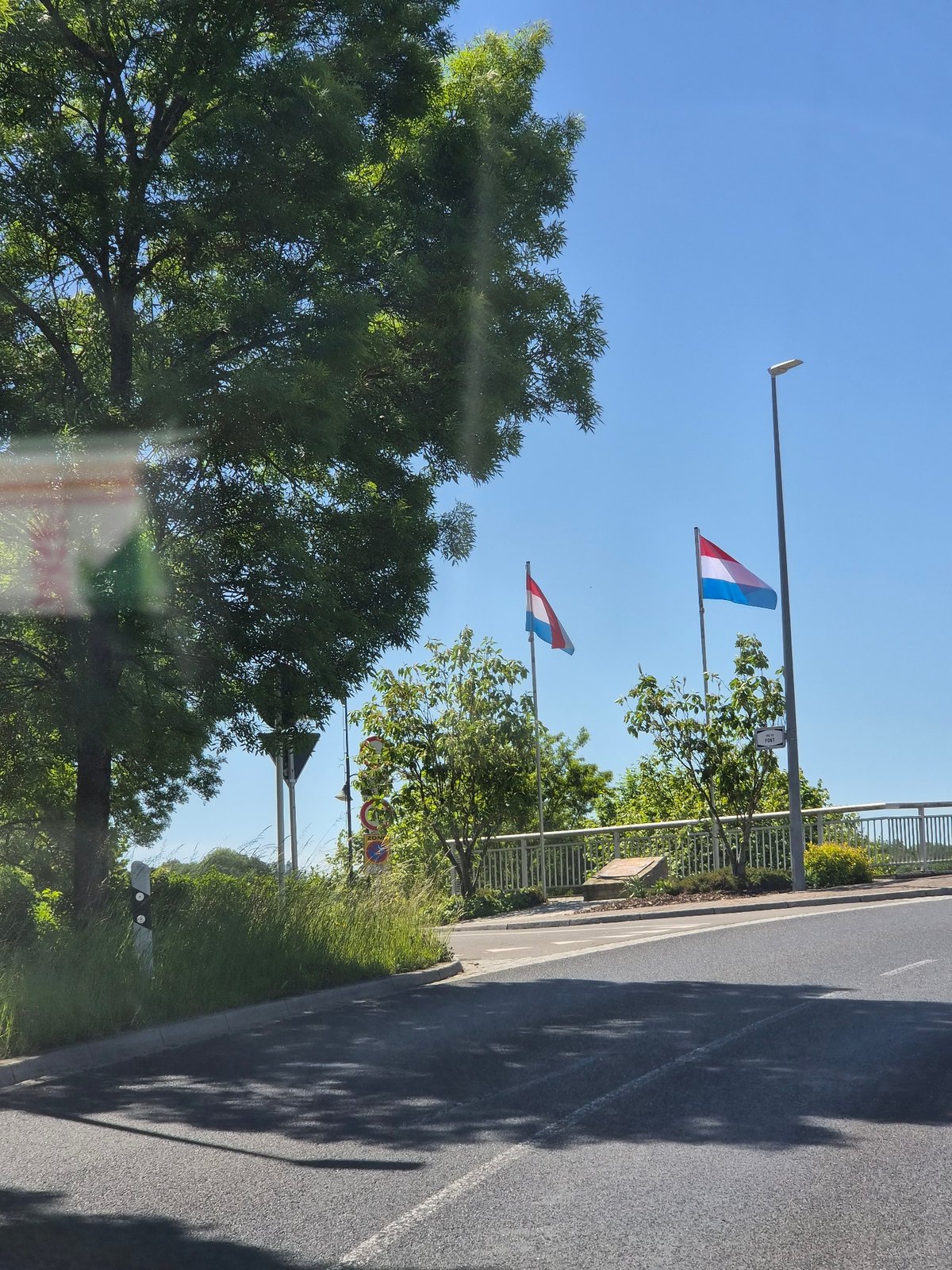 Luxembourg flags displayed along roadside in Oetrange