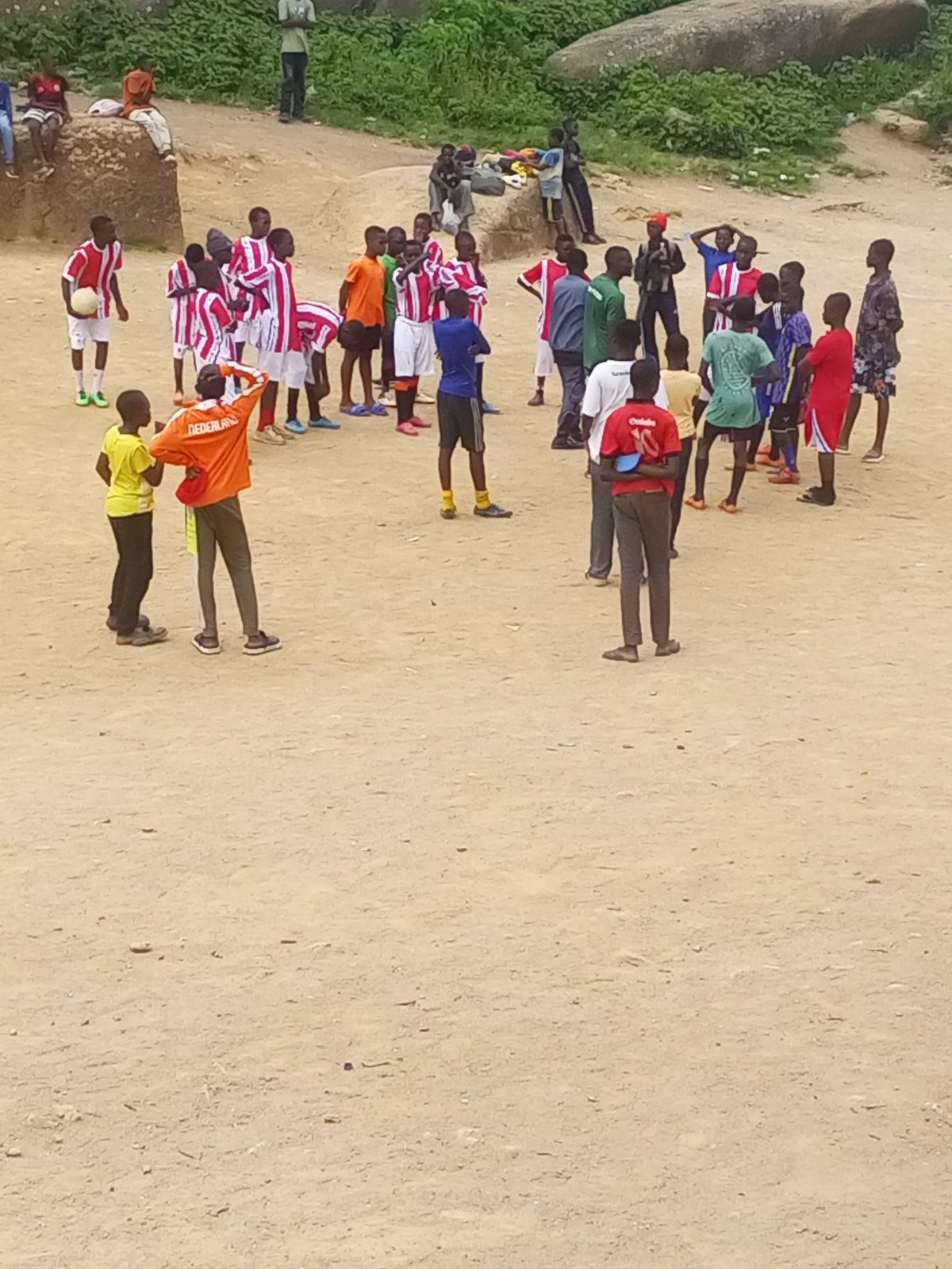 Street football in Jos, framed by Nigeria's granite boulder landscape.