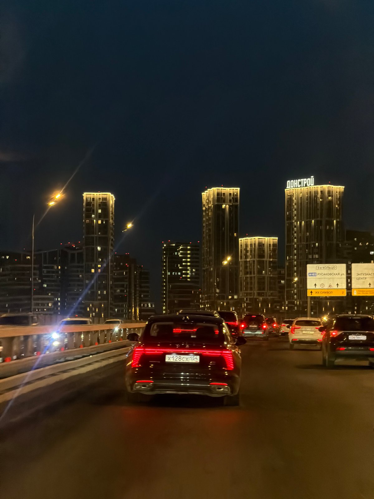 Nighttime traffic captured on Moscow highway amid illuminated skyline