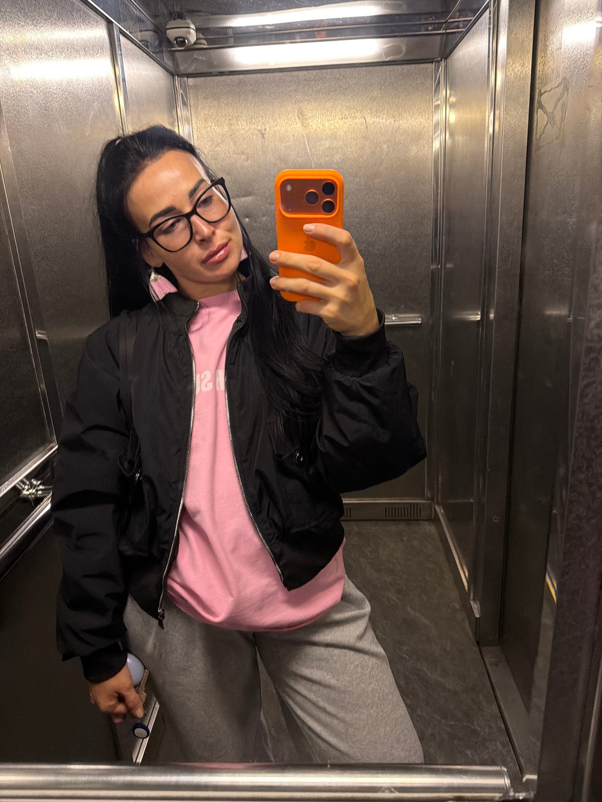 Woman takes selfies, disposes items in Saint Petersburg elevator area