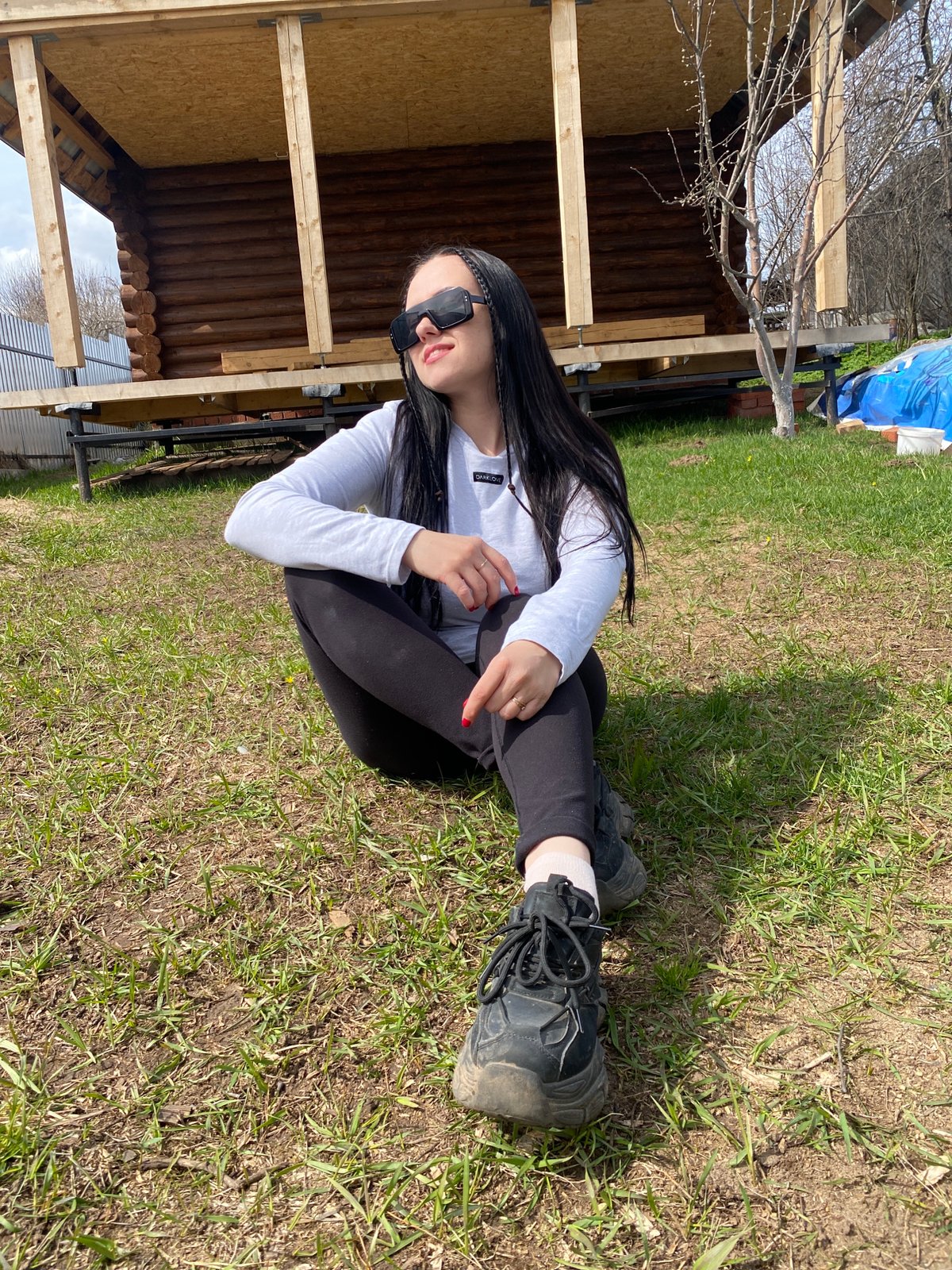 Woman sits outdoors with shopping bag in Chaikovsky, Russia