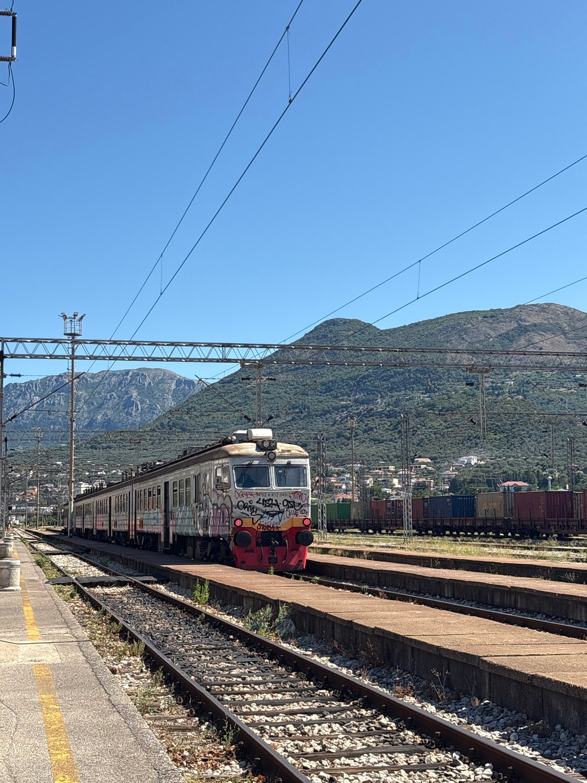 Abandoned yellow Beetle rusts under tarps at Montenegrin station