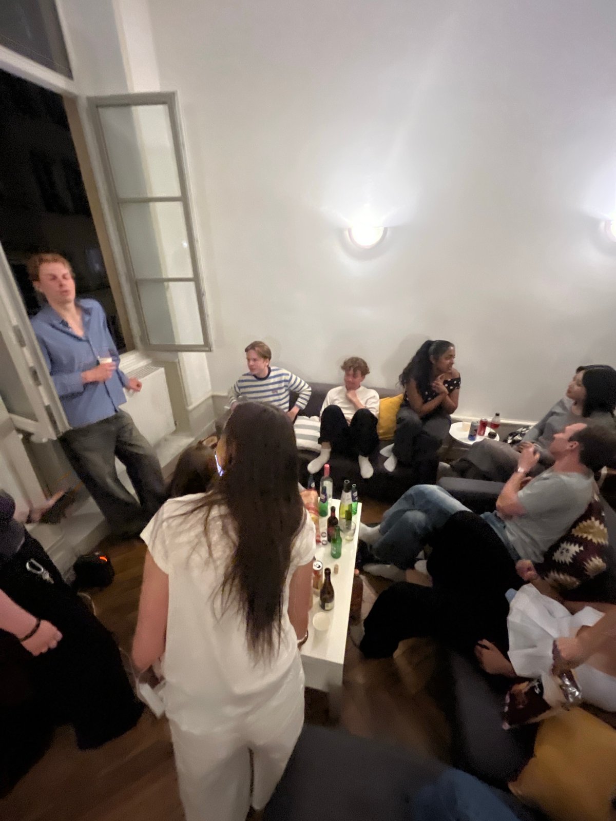 Group gathers at Lyon apartment window, peers outside