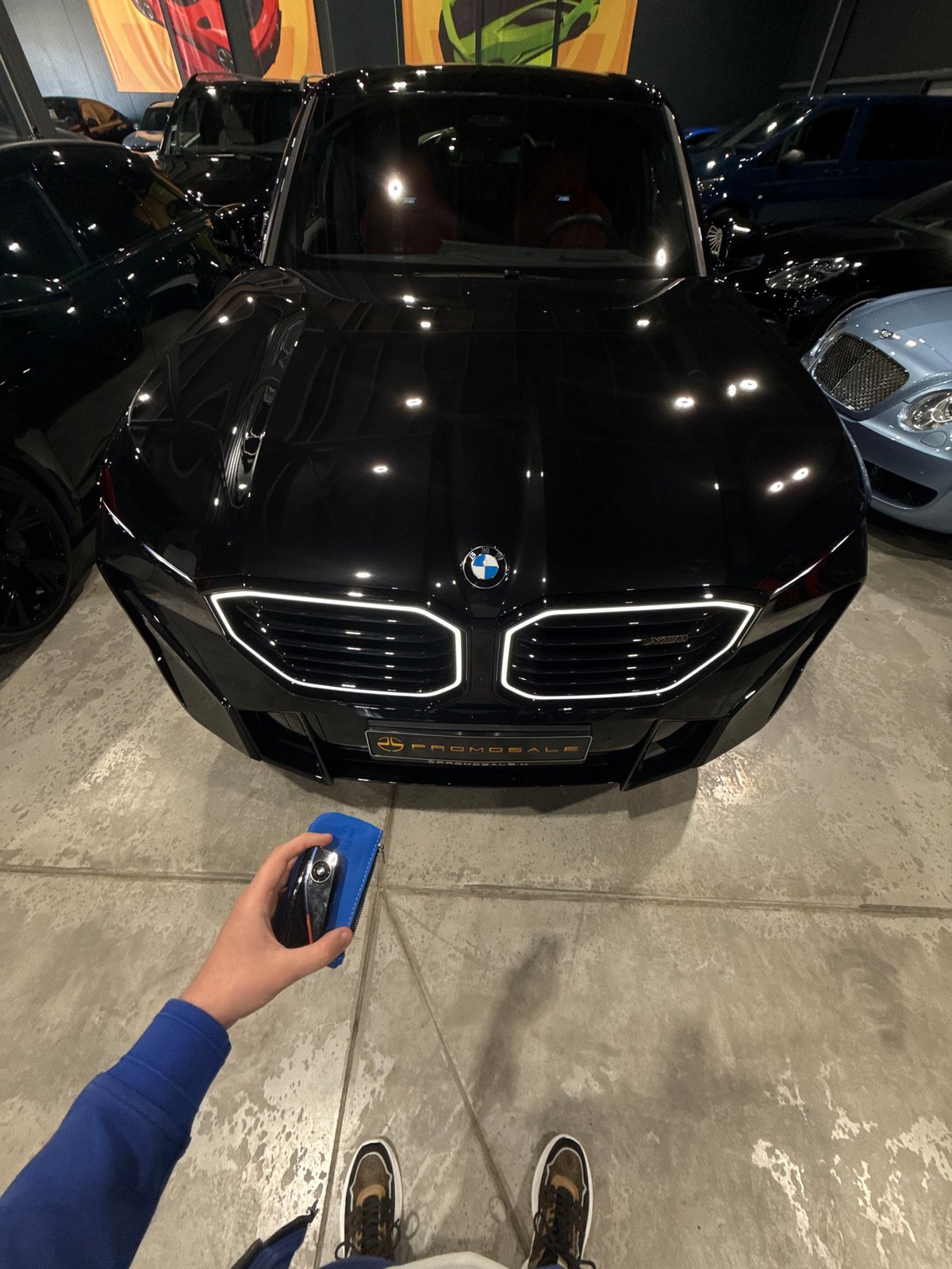 Person with car key approaches BMW in Plovdiv garage