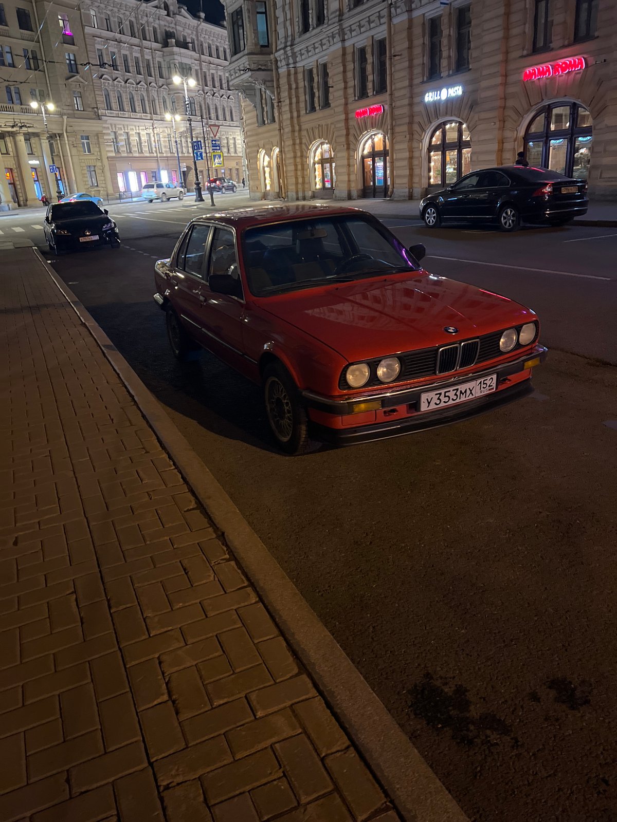 Pedestrians cross nighttime street in Saint Petersburg