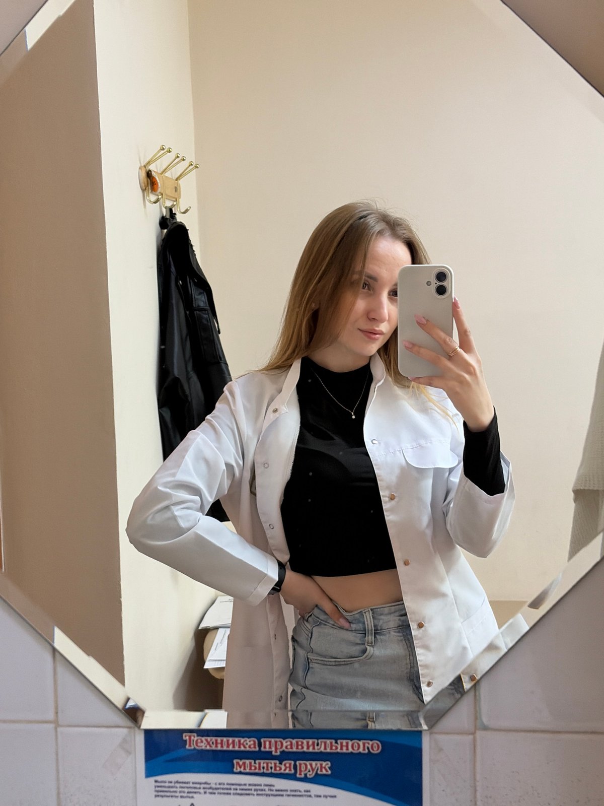 Woman in lab coat takes mirror selfie in Chaikovsky