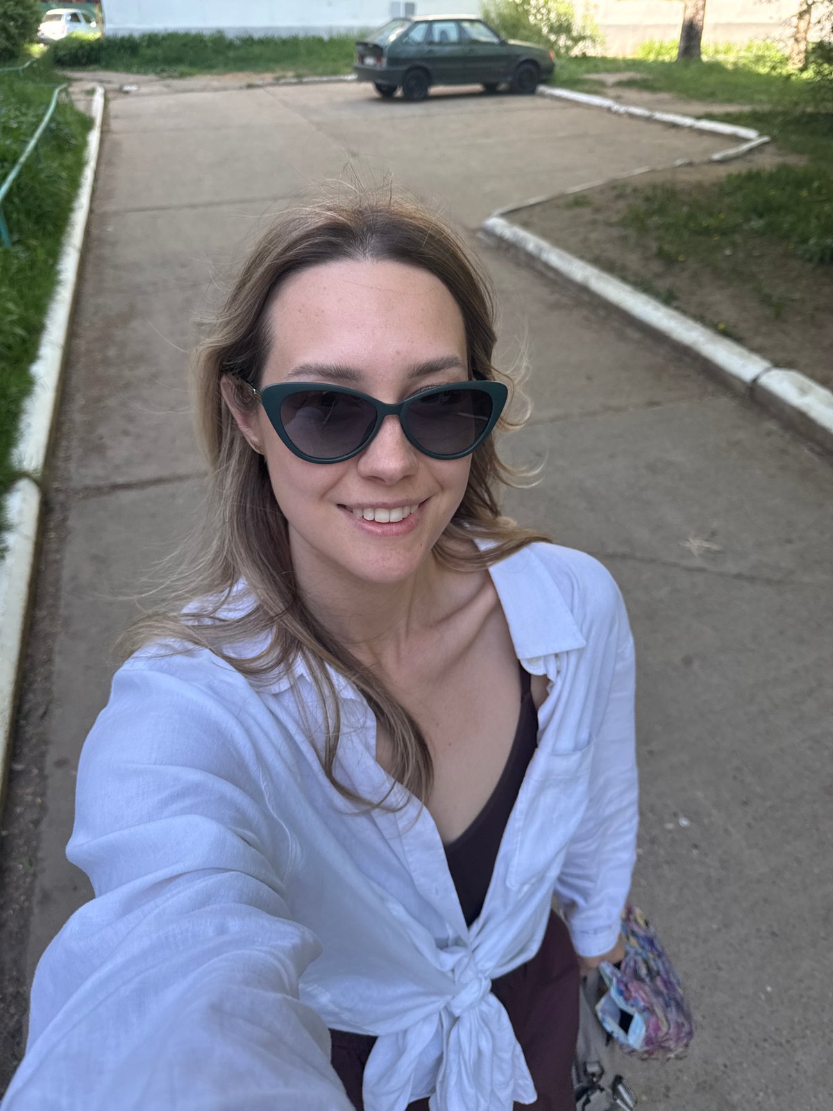 Woman takes selfie on sidewalk in Chaikovsky, Russia