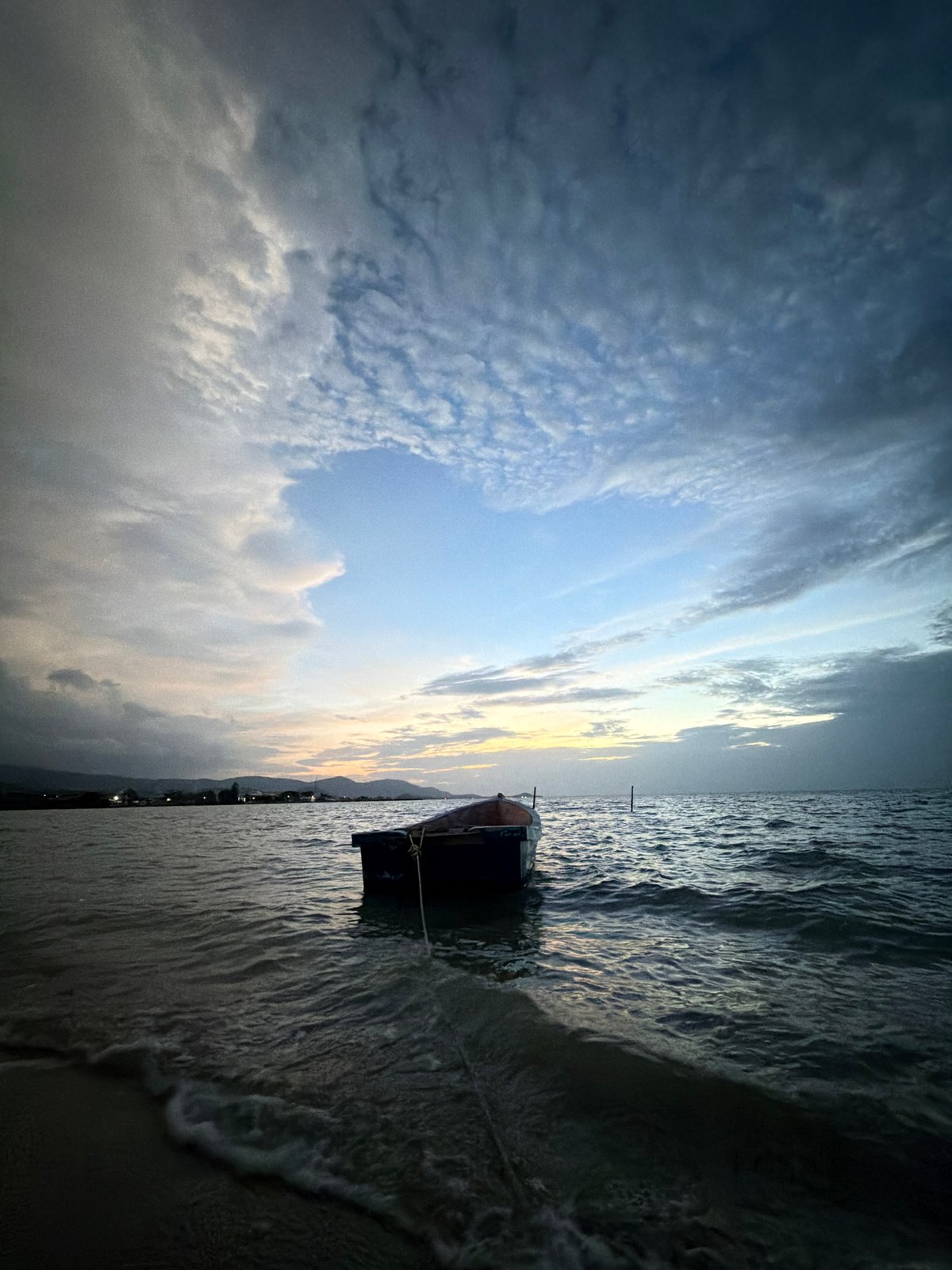 Pulling a rowboat ashore at dusk on Ko Samui