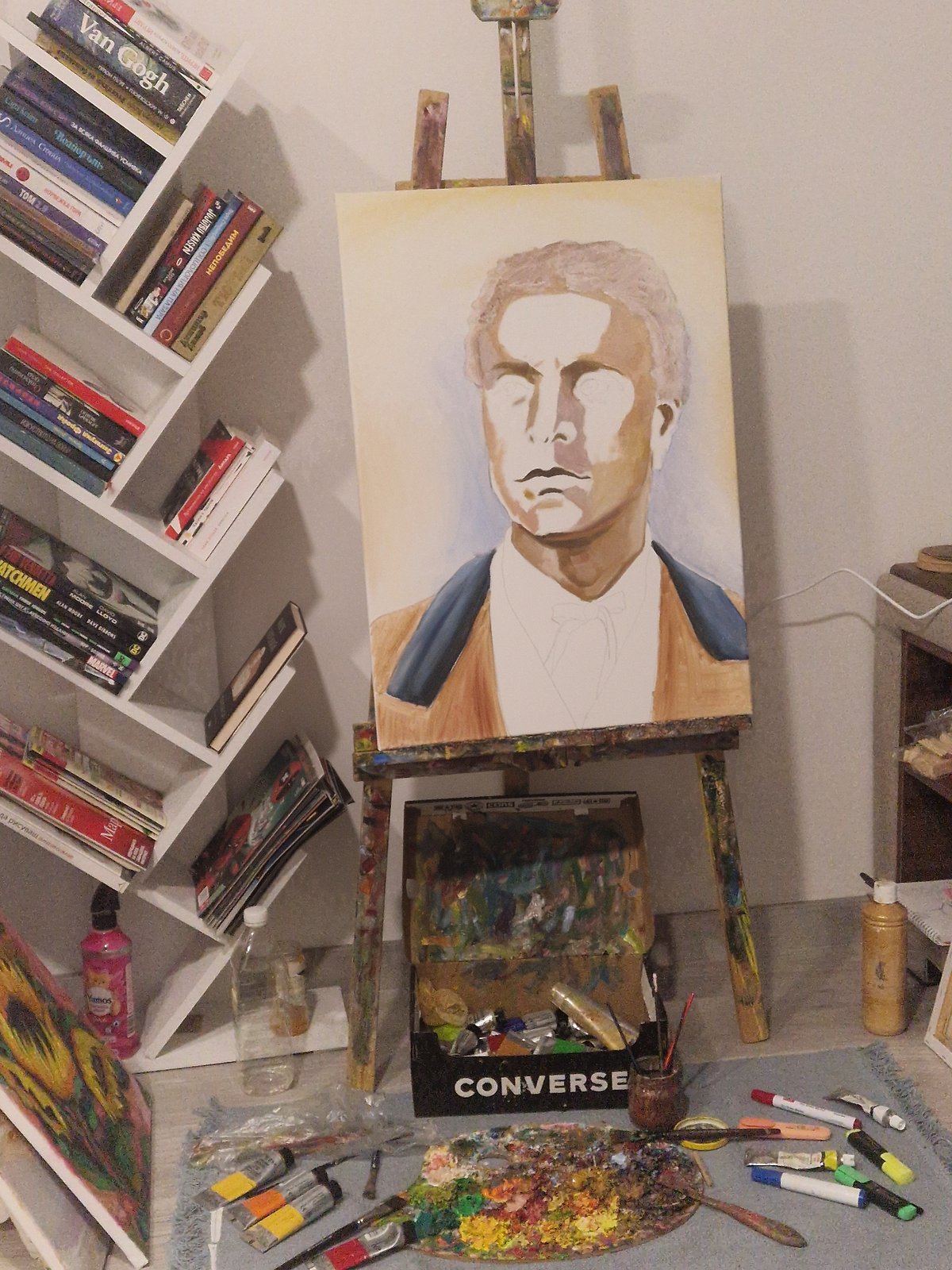 Artist works on unfinished male portrait in studio workspace
