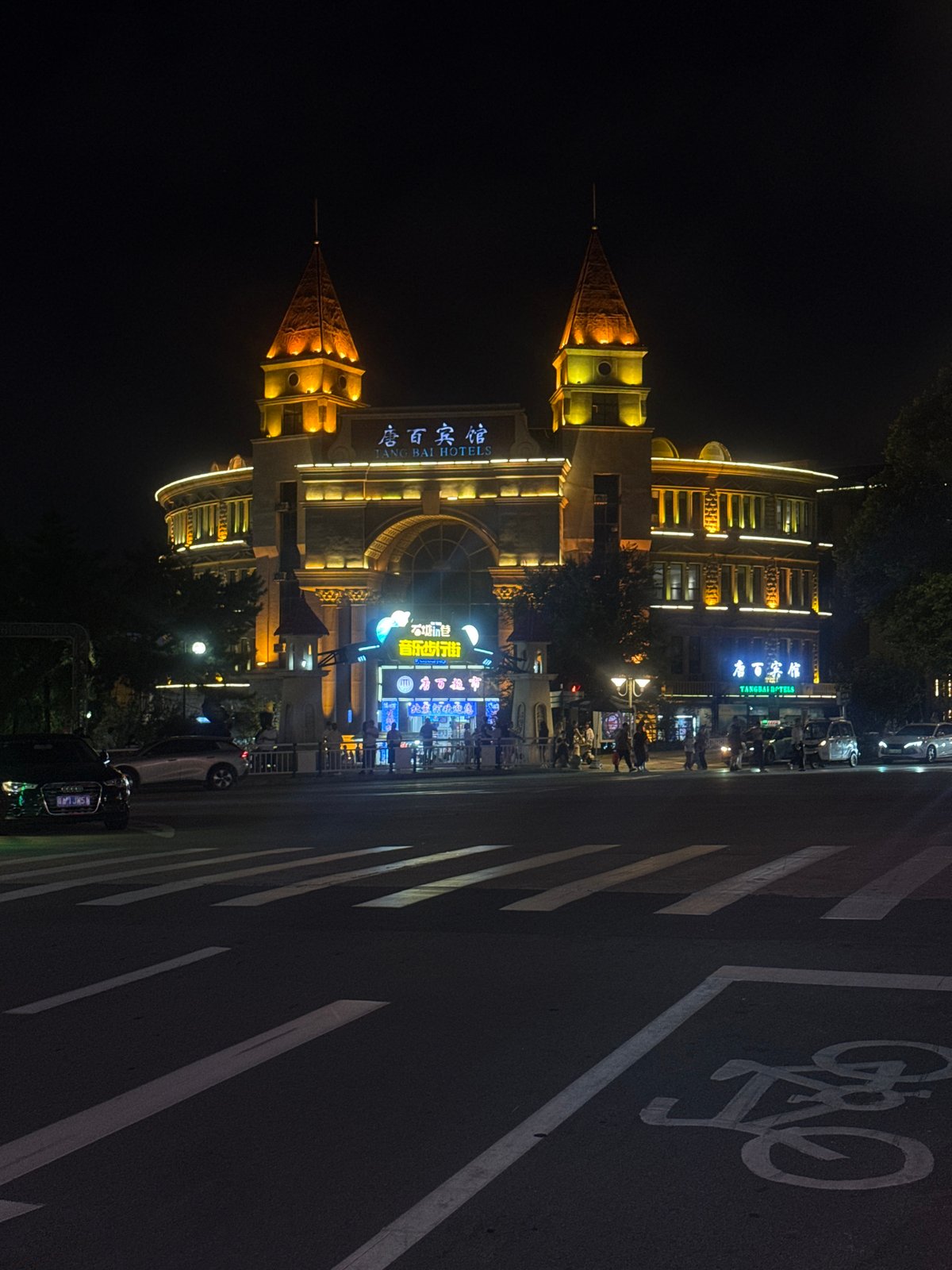 Qinhuangdao after dark: hotel lights, street stalls, and waterfront performance