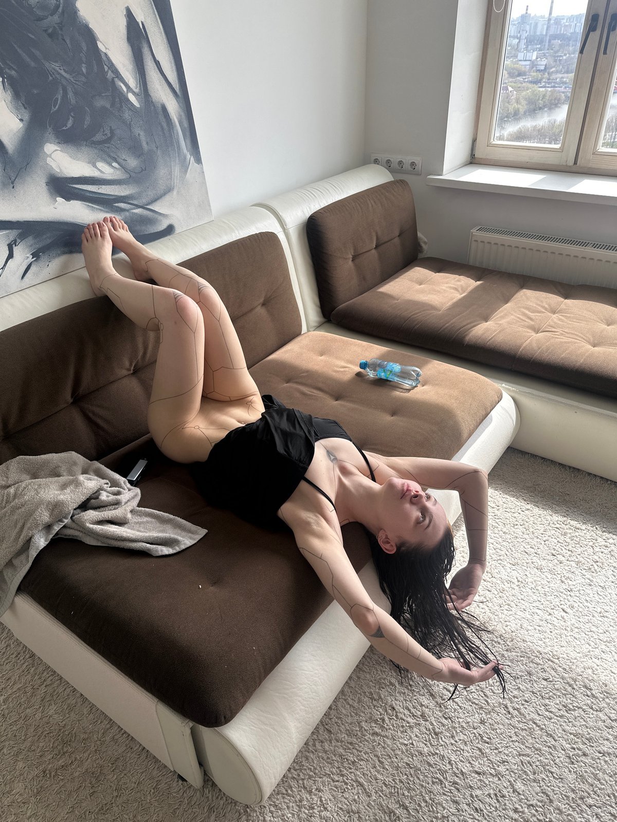 Woman in contemplative moment on sofa in Khimki home
