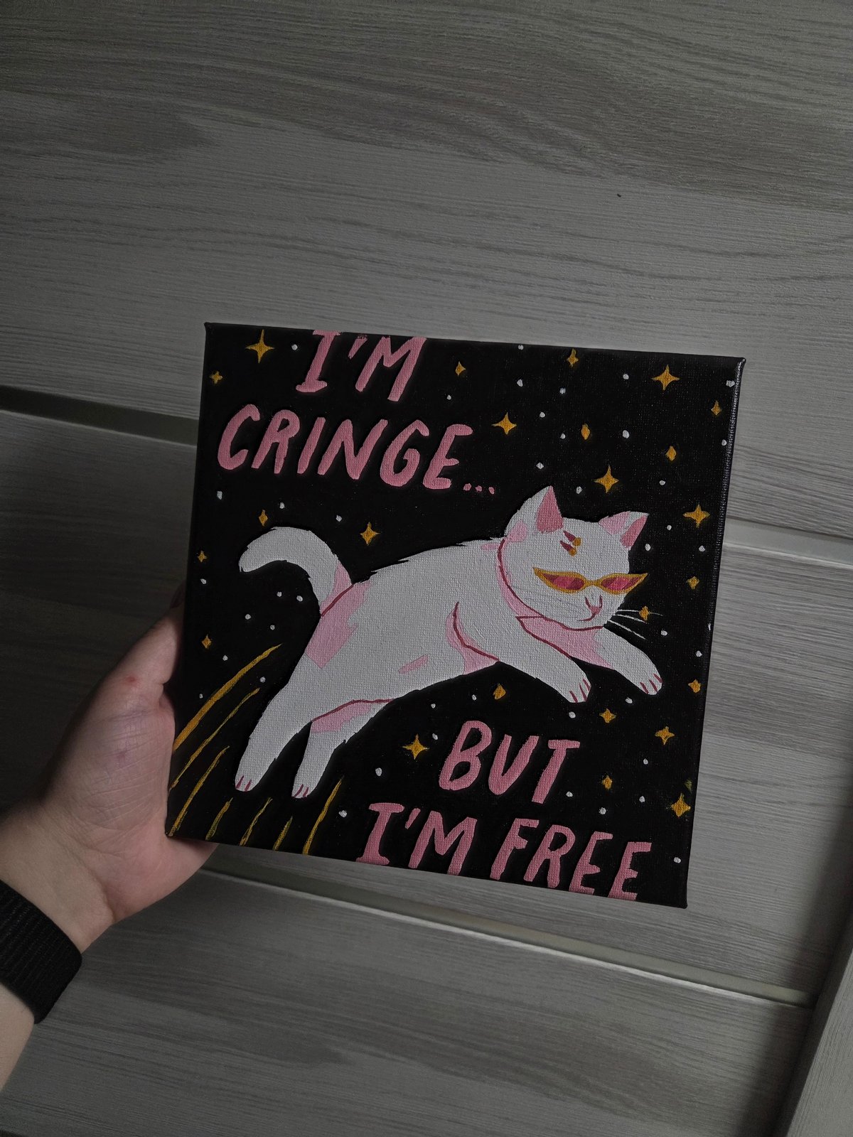 Person displays small paintings and personal items collection