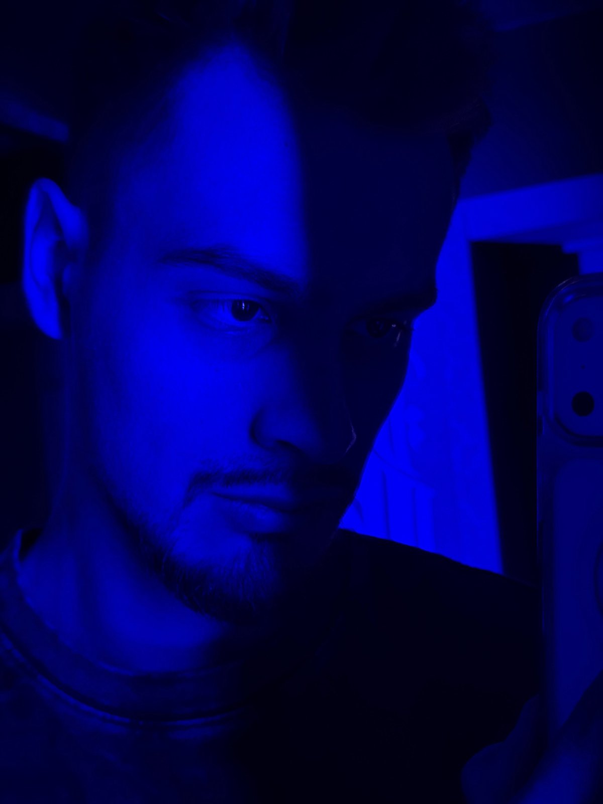 Man takes selfies in blue-lit environment in Krasnoyarsk
