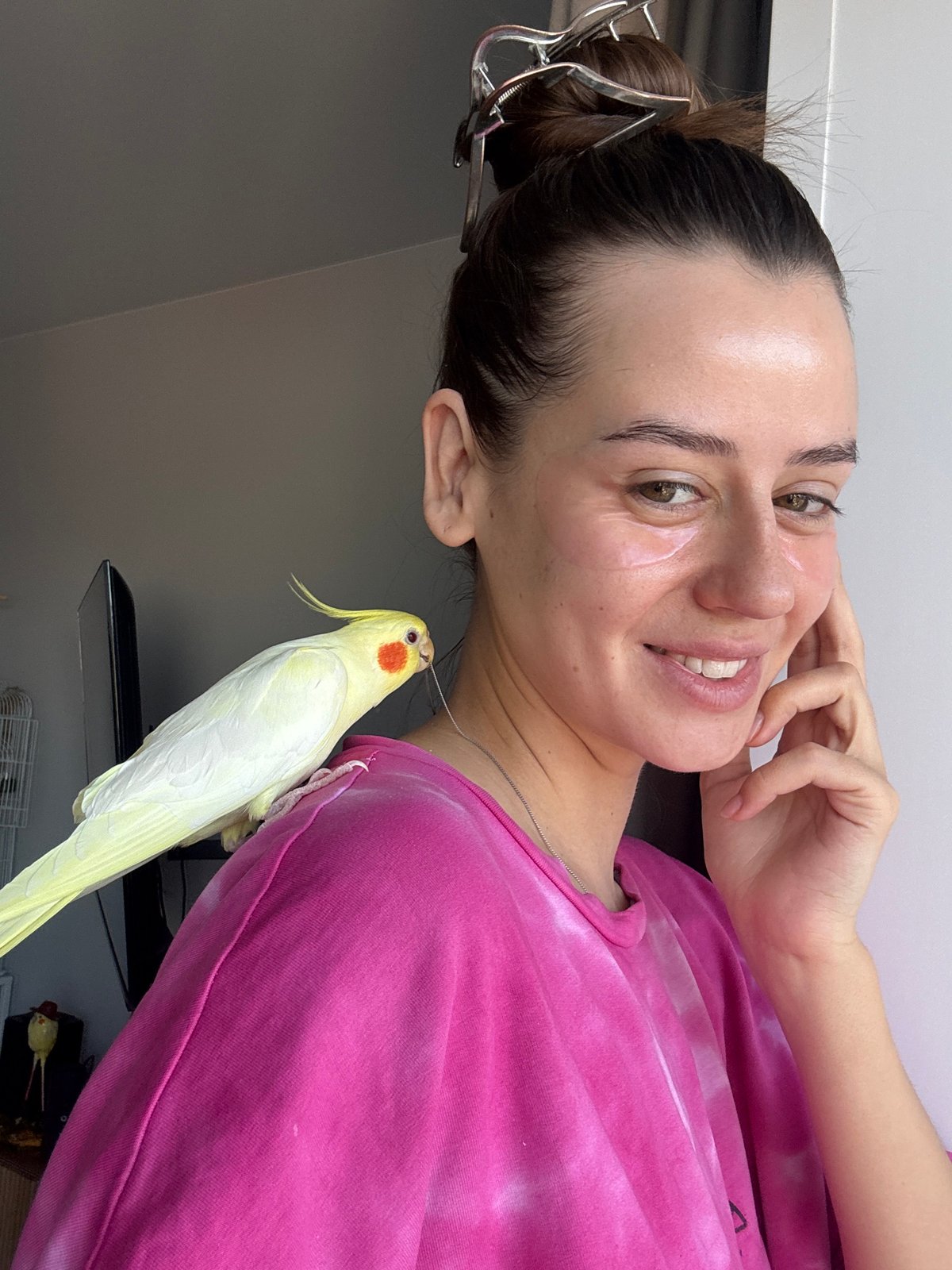 Woman poses with pet cockatiel during breakfast in Krasnoyarsk