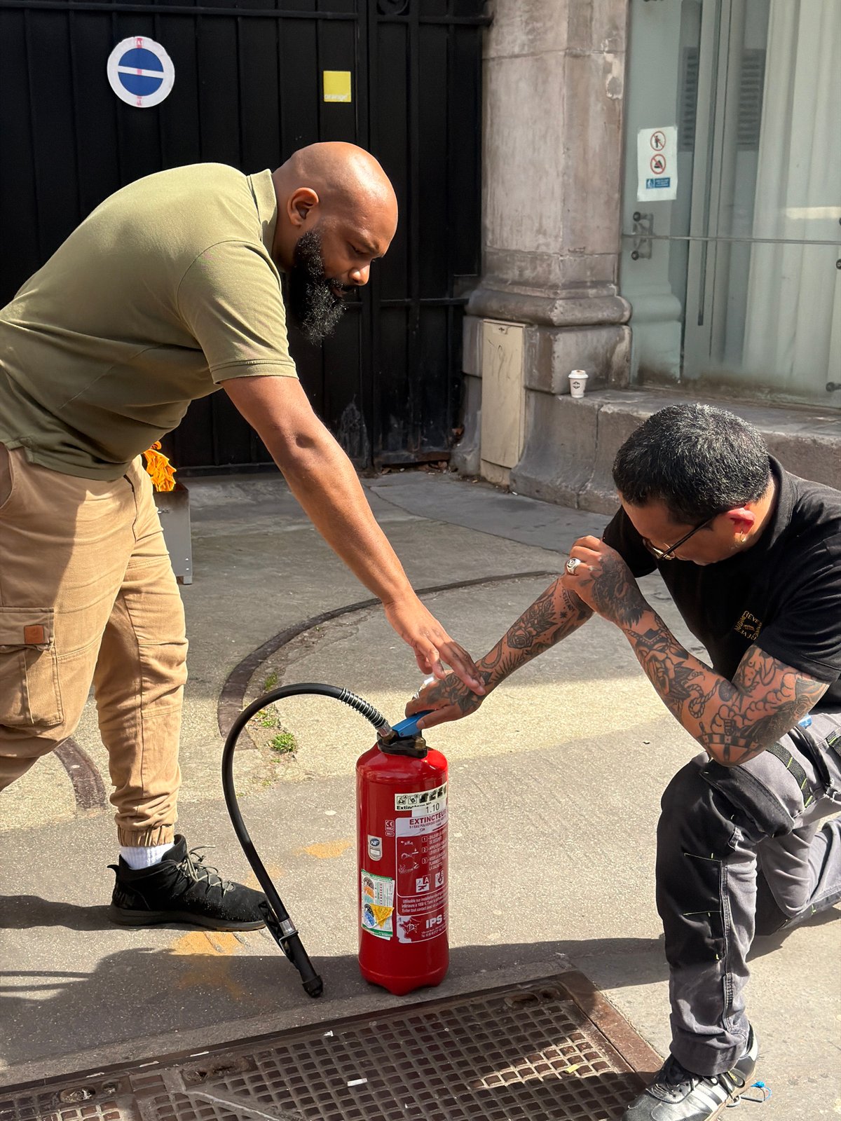 Men use fire extinguisher on burning electrical box in Paris