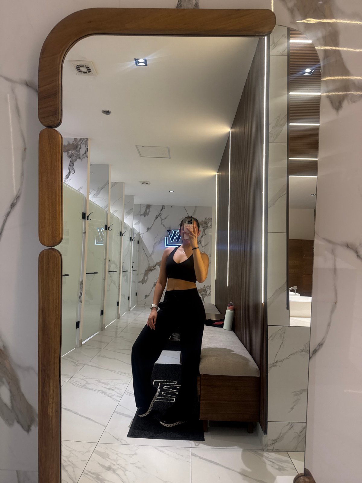 Woman takes mirror selfie in modern room in Puebla