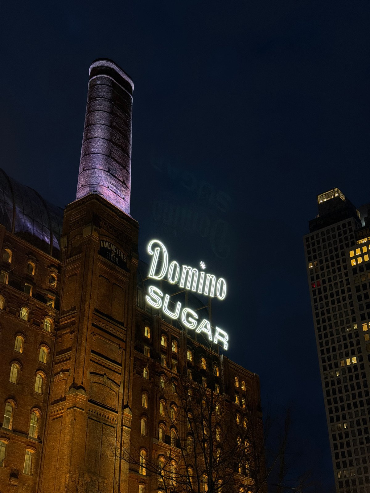 Domino Sugar Refinery building illuminated at night in Brooklyn