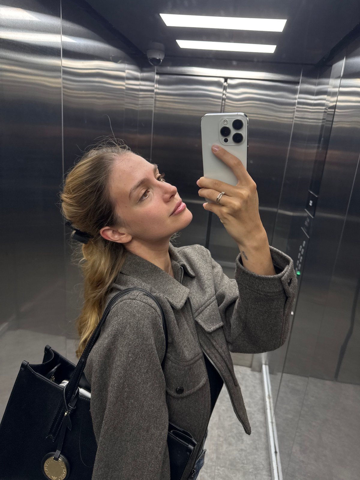 Woman Takes Mirror Selfie in Elevator