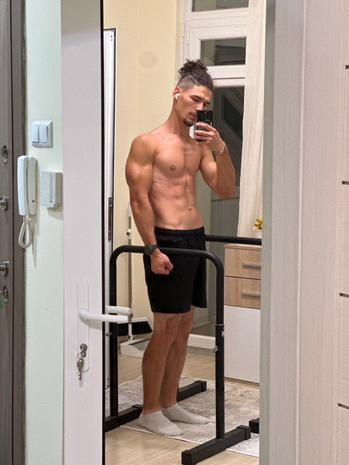 Mirror selfie in Varna apartment, black shorts and bun