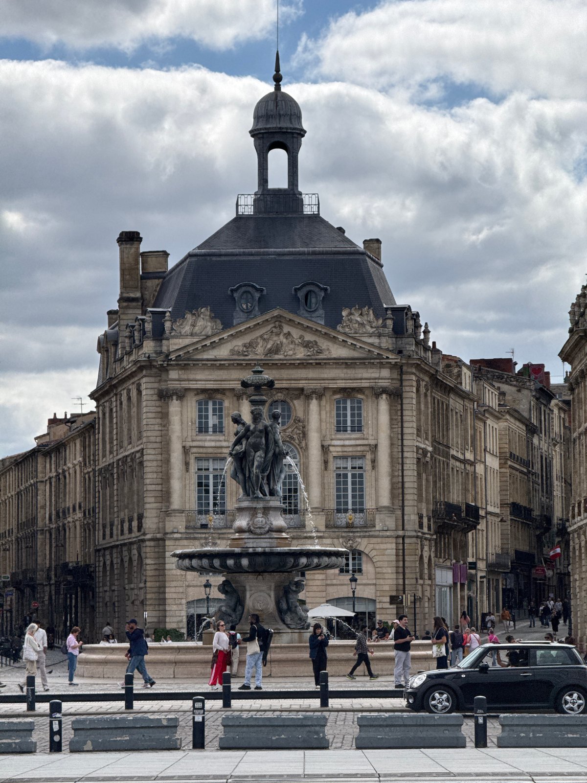 Tourist documents Place de la Bourse landmarks during cloudy afternoon