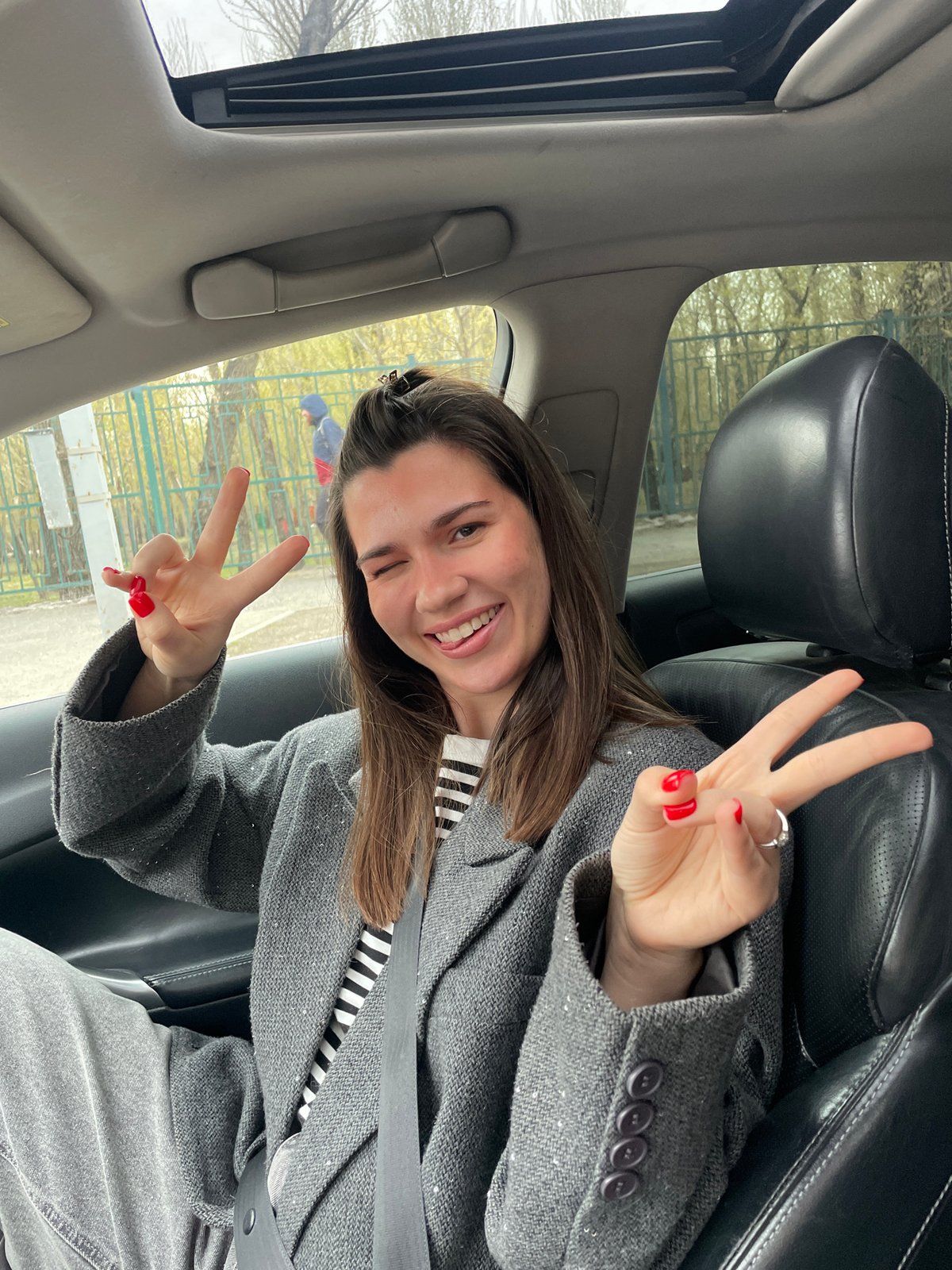 Woman makes peace sign while seated in car in Krasnoyarsk