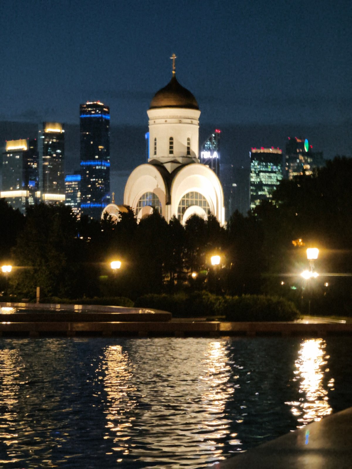 Night lights along the Moskva River — church, fountain, city skyline
