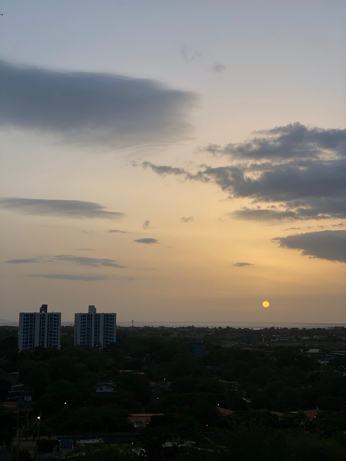Sunset over Juan Griego alongside footage of a fire-damaged building