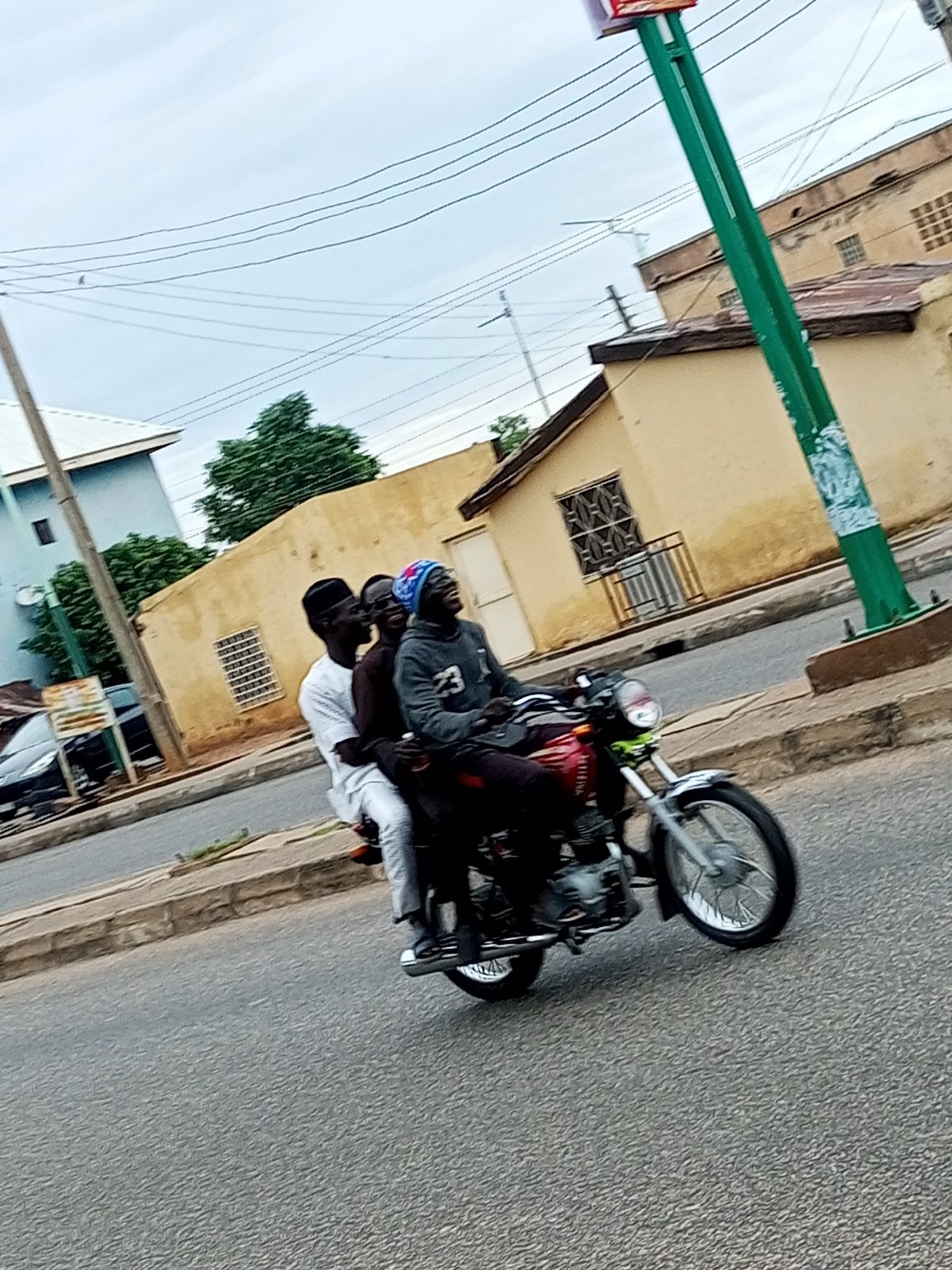 Everyday street life across two Nigerian neighborhoods on an overcast morning