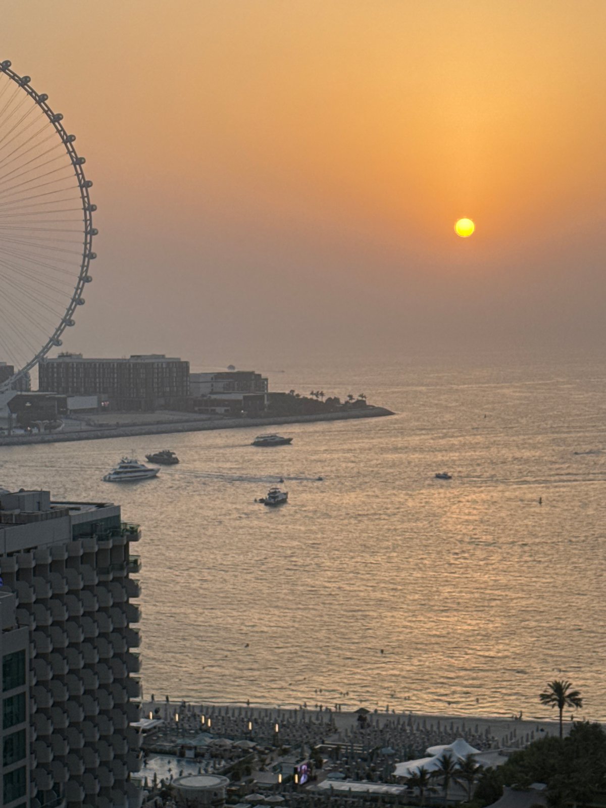Sunset over Dubai's coastline, watched from a high-rise room