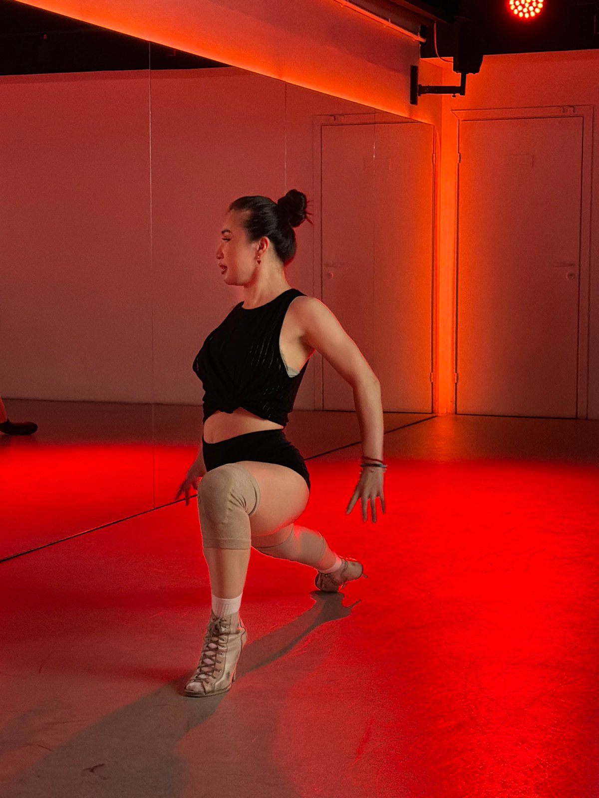 Woman practices dance in red-lit Moscow studio
