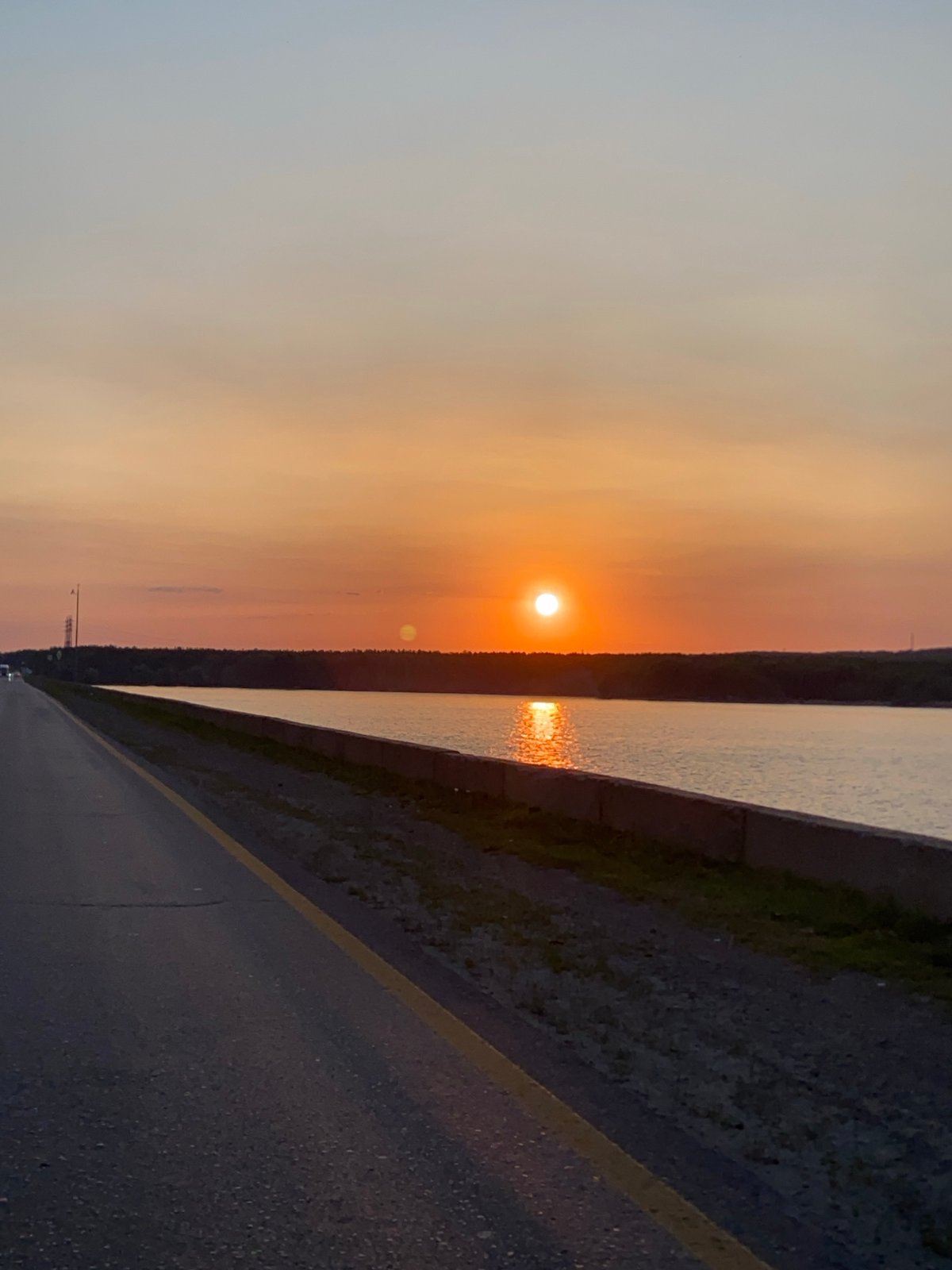 Roadside sunset over calm water, golden hour from multiple angles