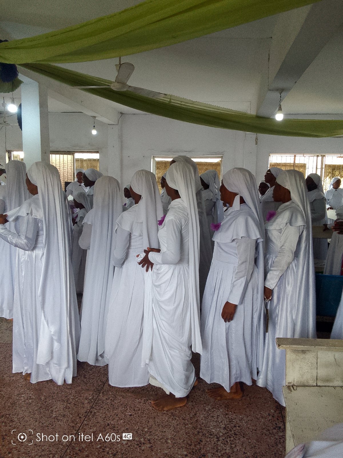 White-robed group gathers indoors for apparent ceremonial activity