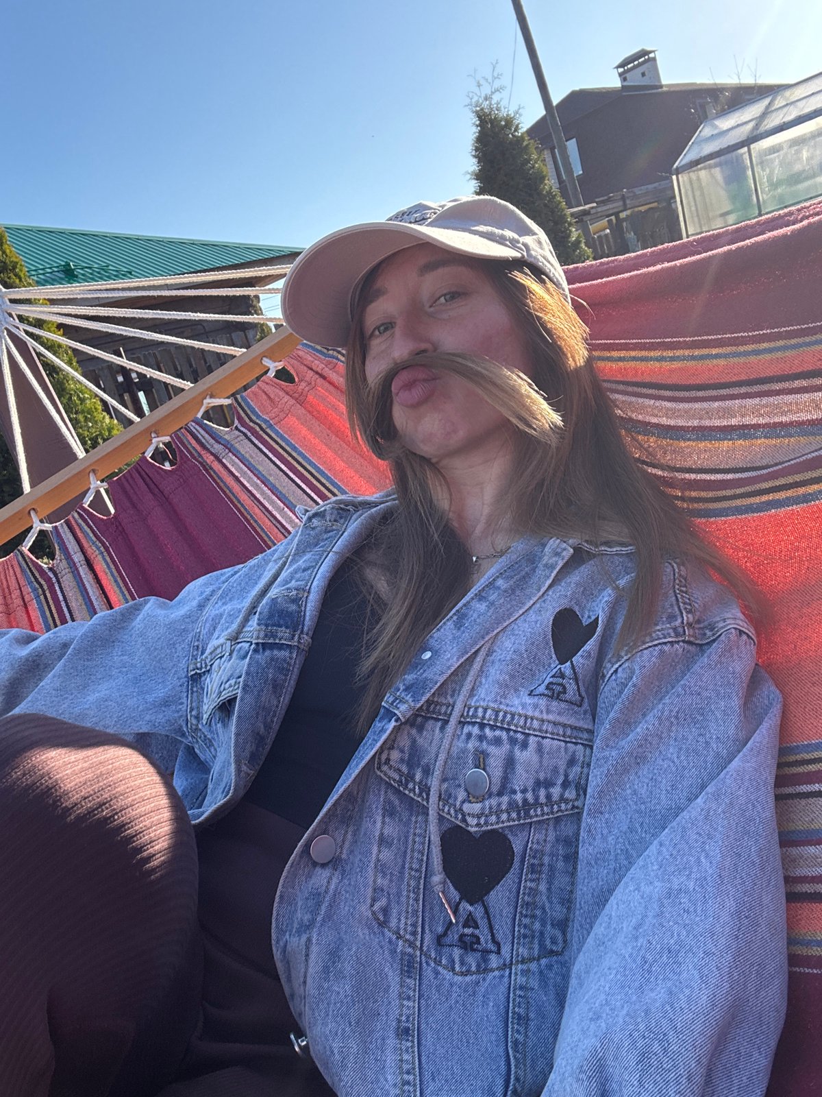 Woman enjoys afternoon hammock time and bubble-blowing in Russian backyard