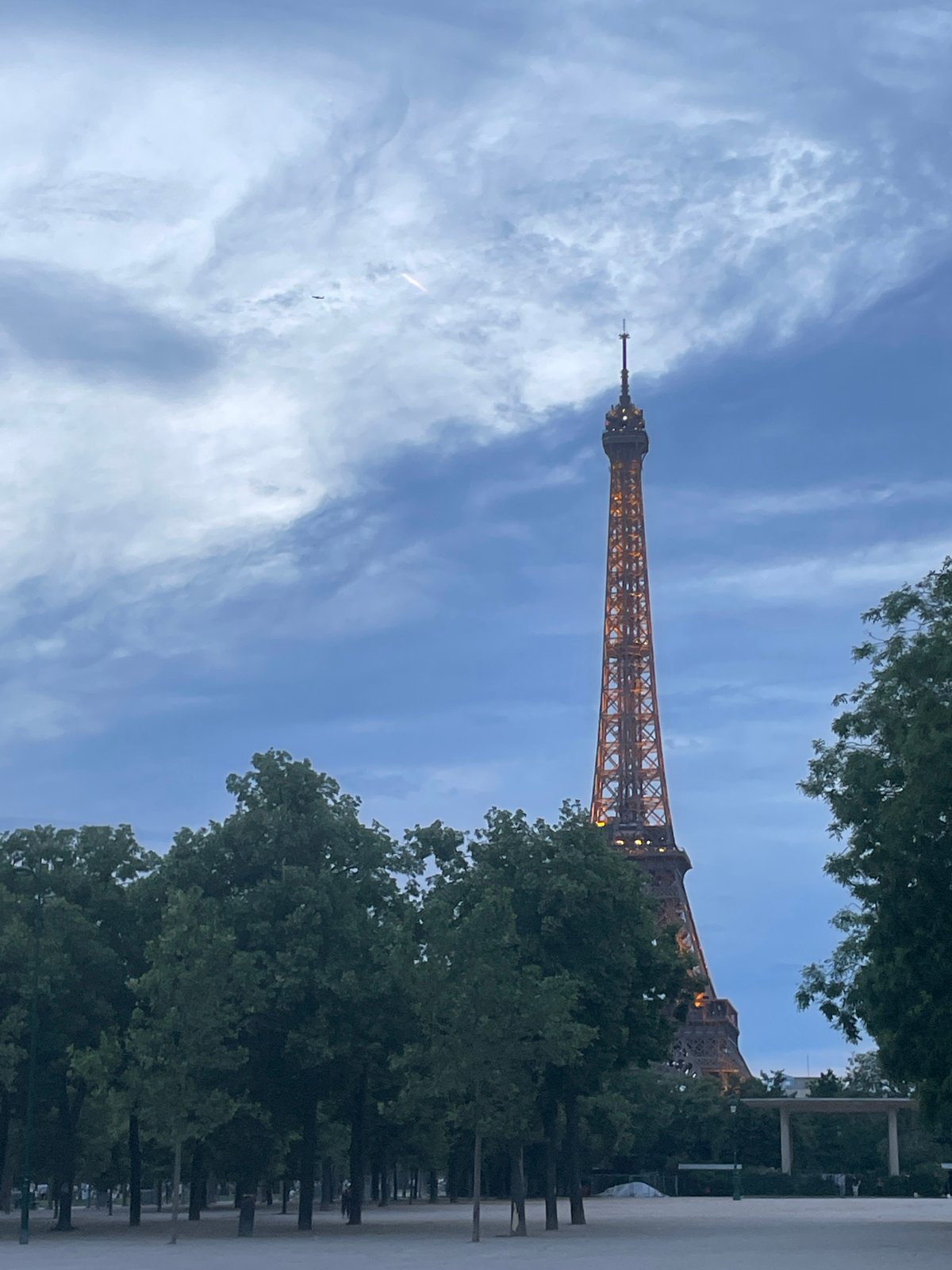 Evening stroll captures illuminated Eiffel Tower and Parisian street life