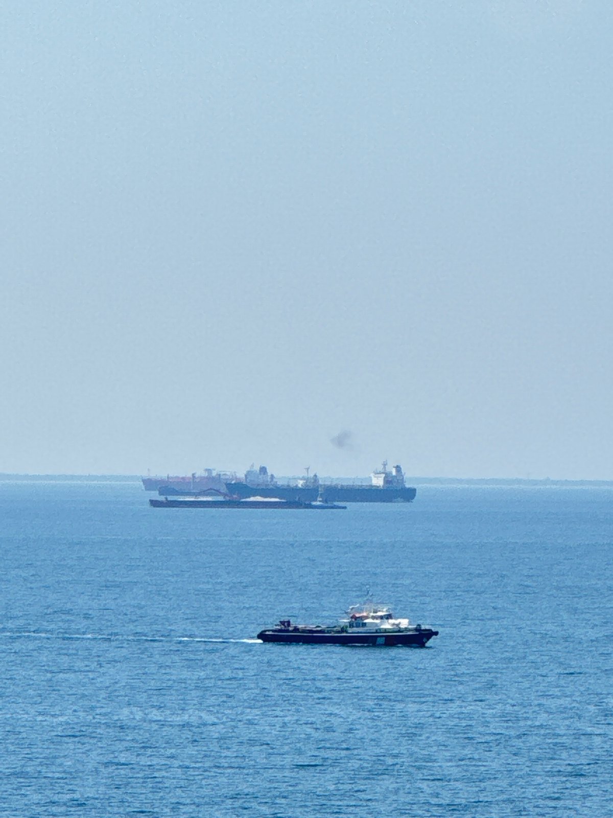 Cargo ships moving through calm Adriatic waters near an Italian port