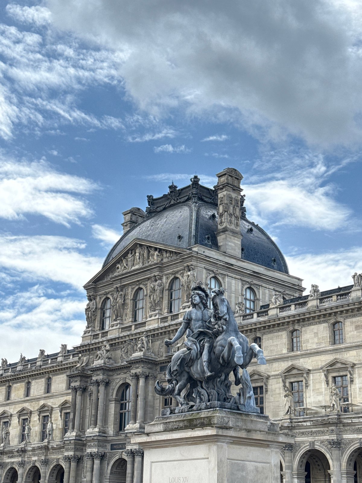 Tourist documents Louvre's architecture during morning museum visit