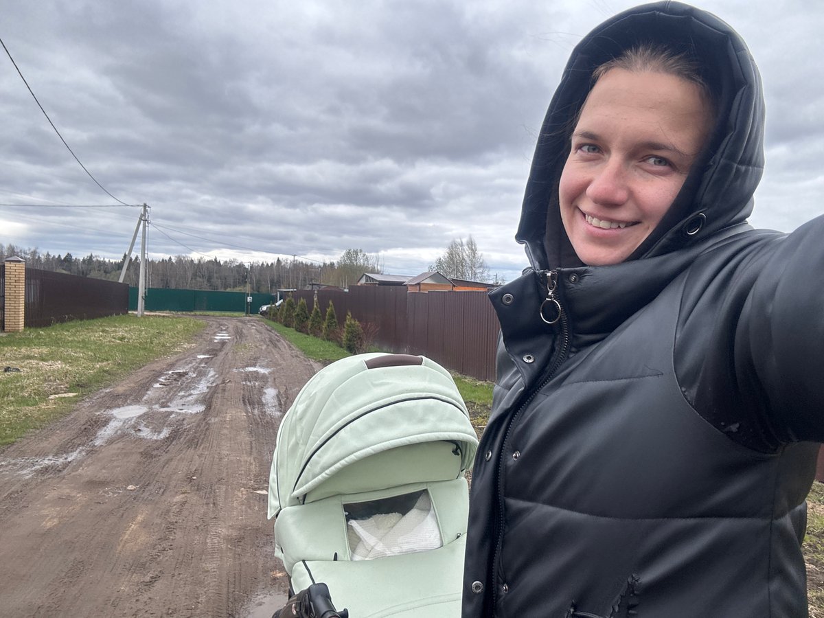 Woman with stroller walks muddy roads in Russian village