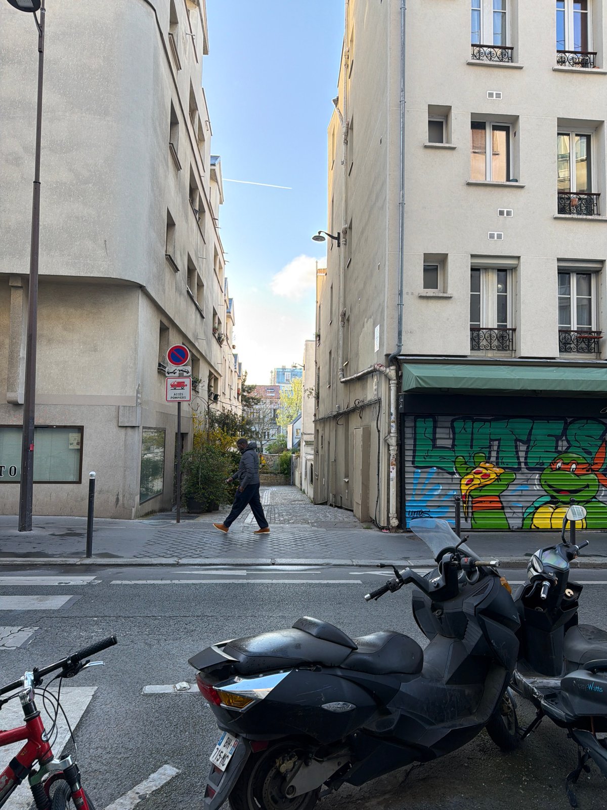 Woman rides Lime e-bike through narrow Paris street