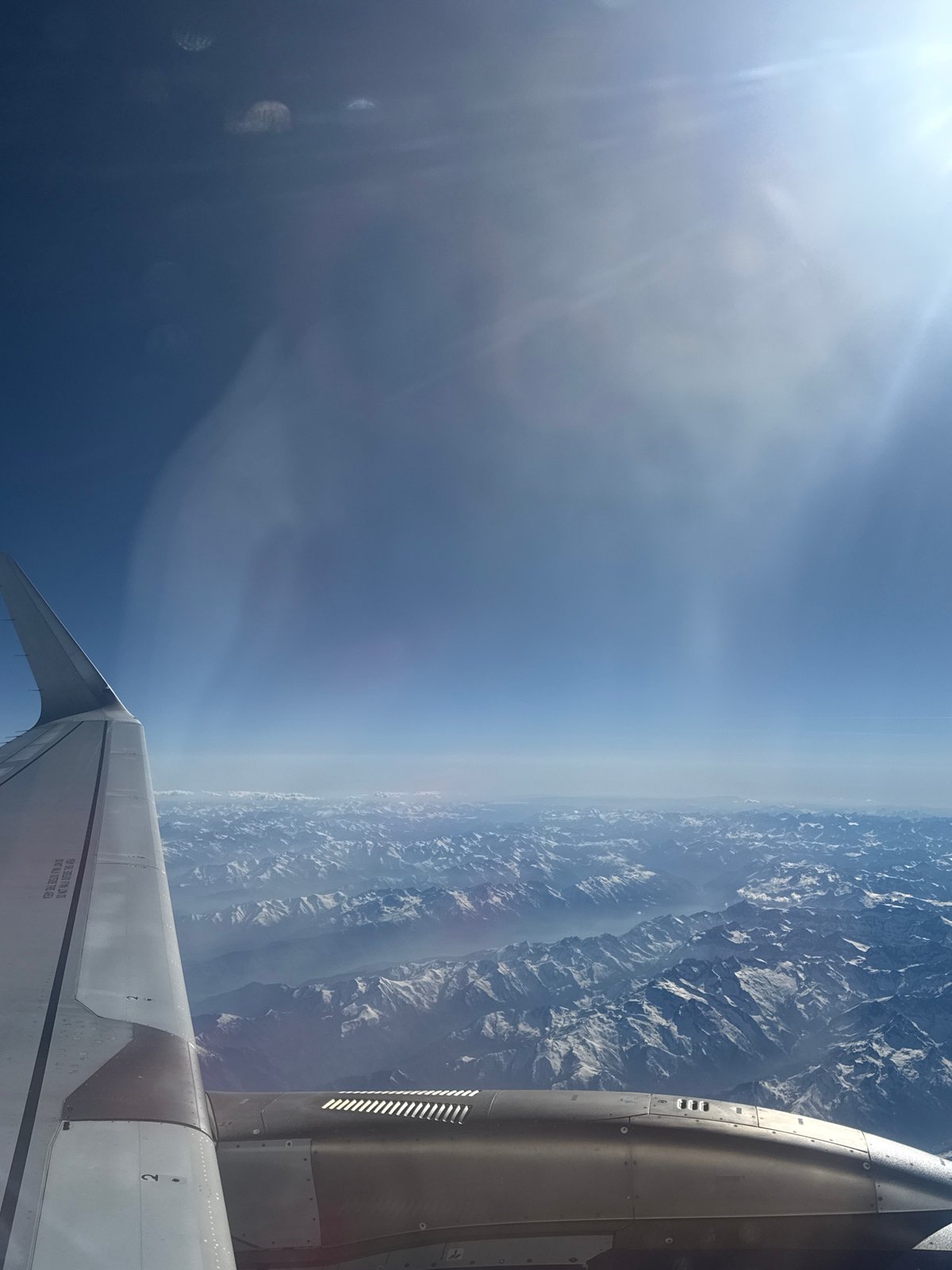 Aircraft passenger captures mountain view through hazy atmosphere