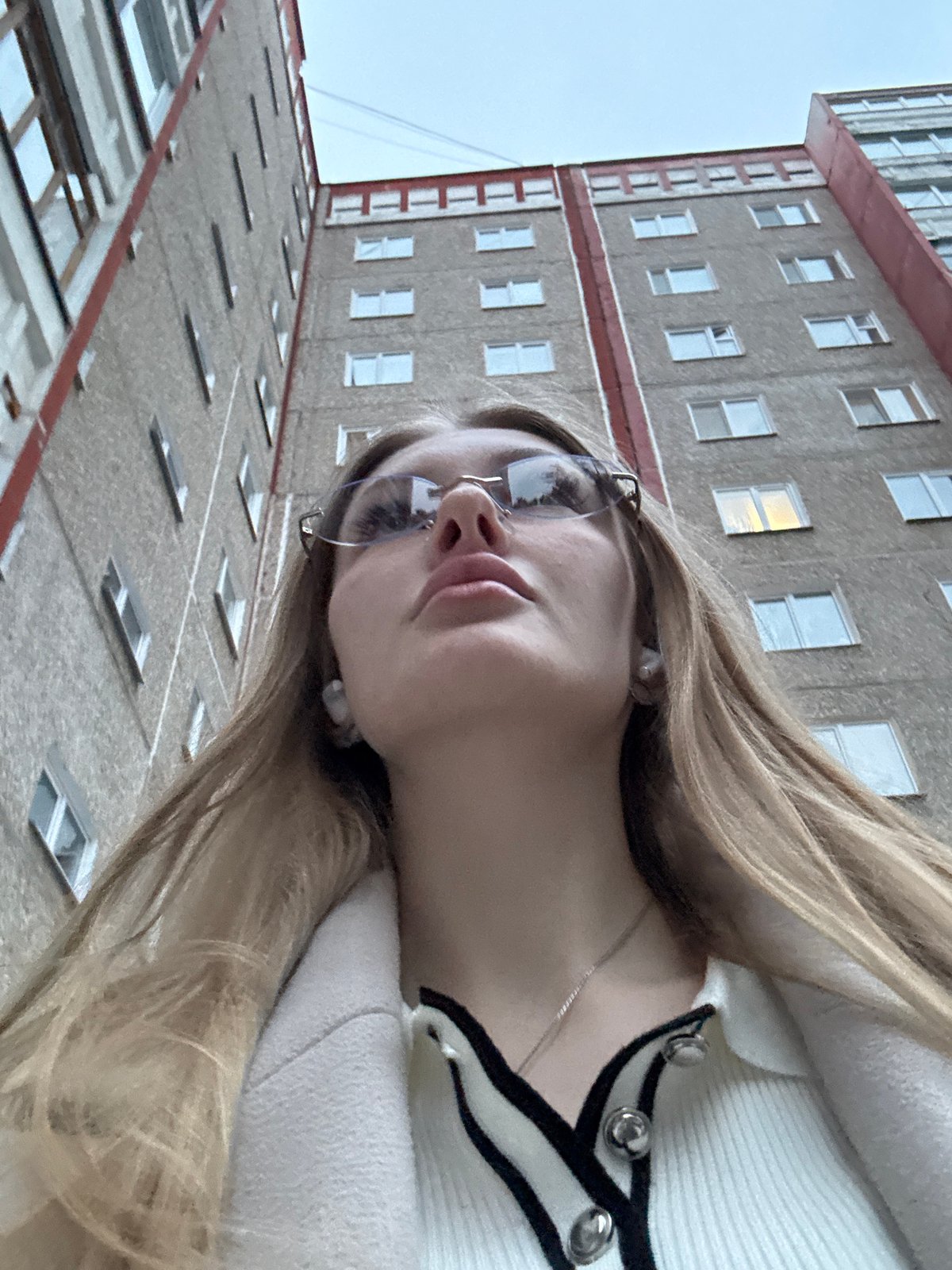 Woman takes selfies near apartment building in Perm, Russia