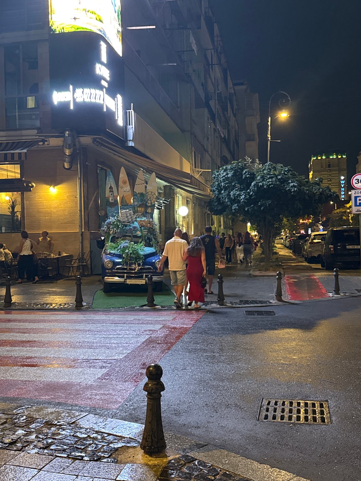 Rainy night on Batumi's Rustaveli Avenue, flower-decked vintage car