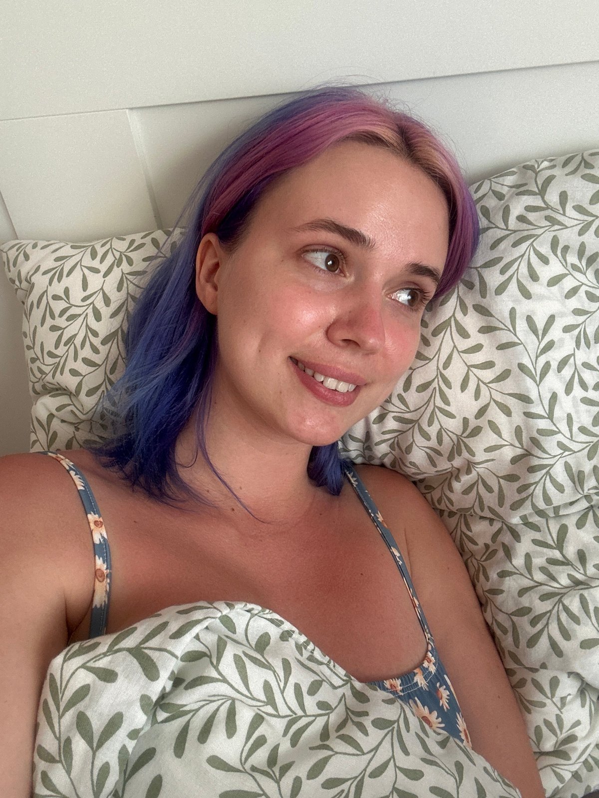Woman with colorful hair rests peacefully in Gijón bedroom