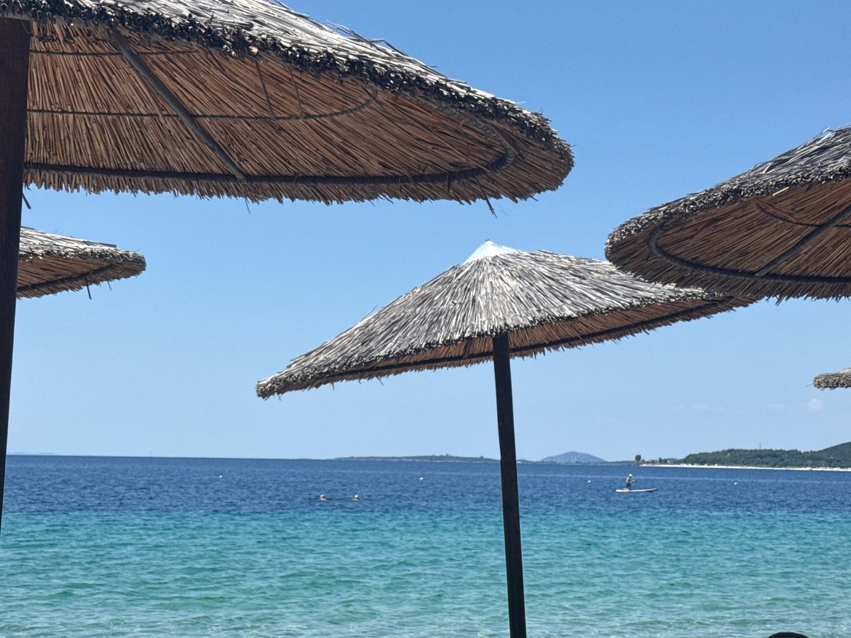 Thatched umbrellas on a sunny Toroni beach, Greece