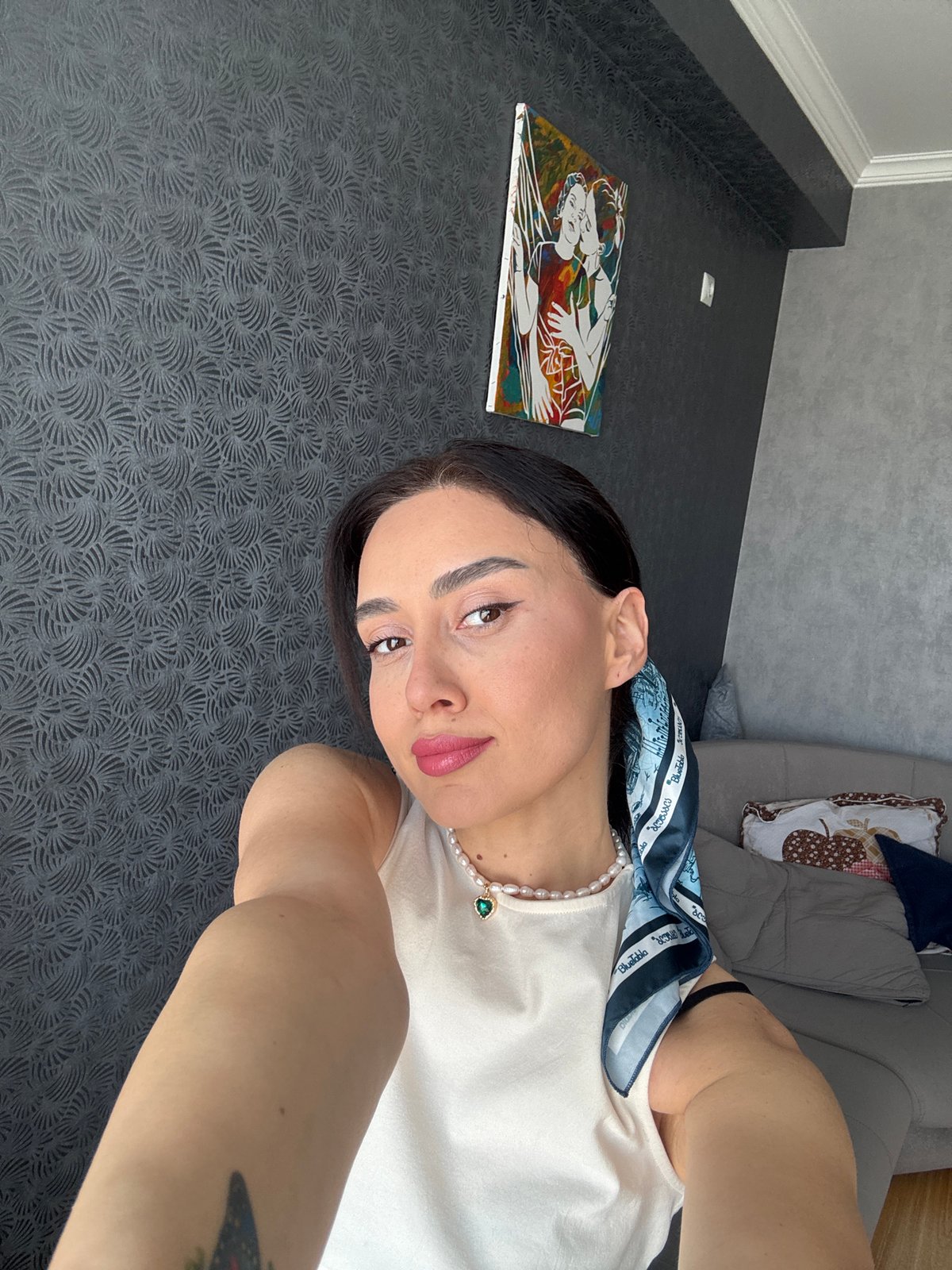 Woman takes morning selfies on sofa in Tbilisi apartment