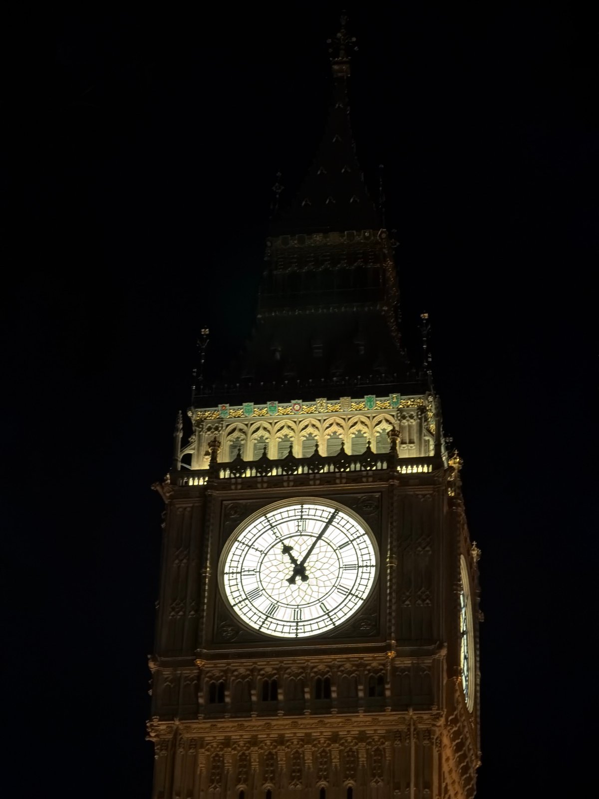 Big Ben clock face photographed illuminated at night