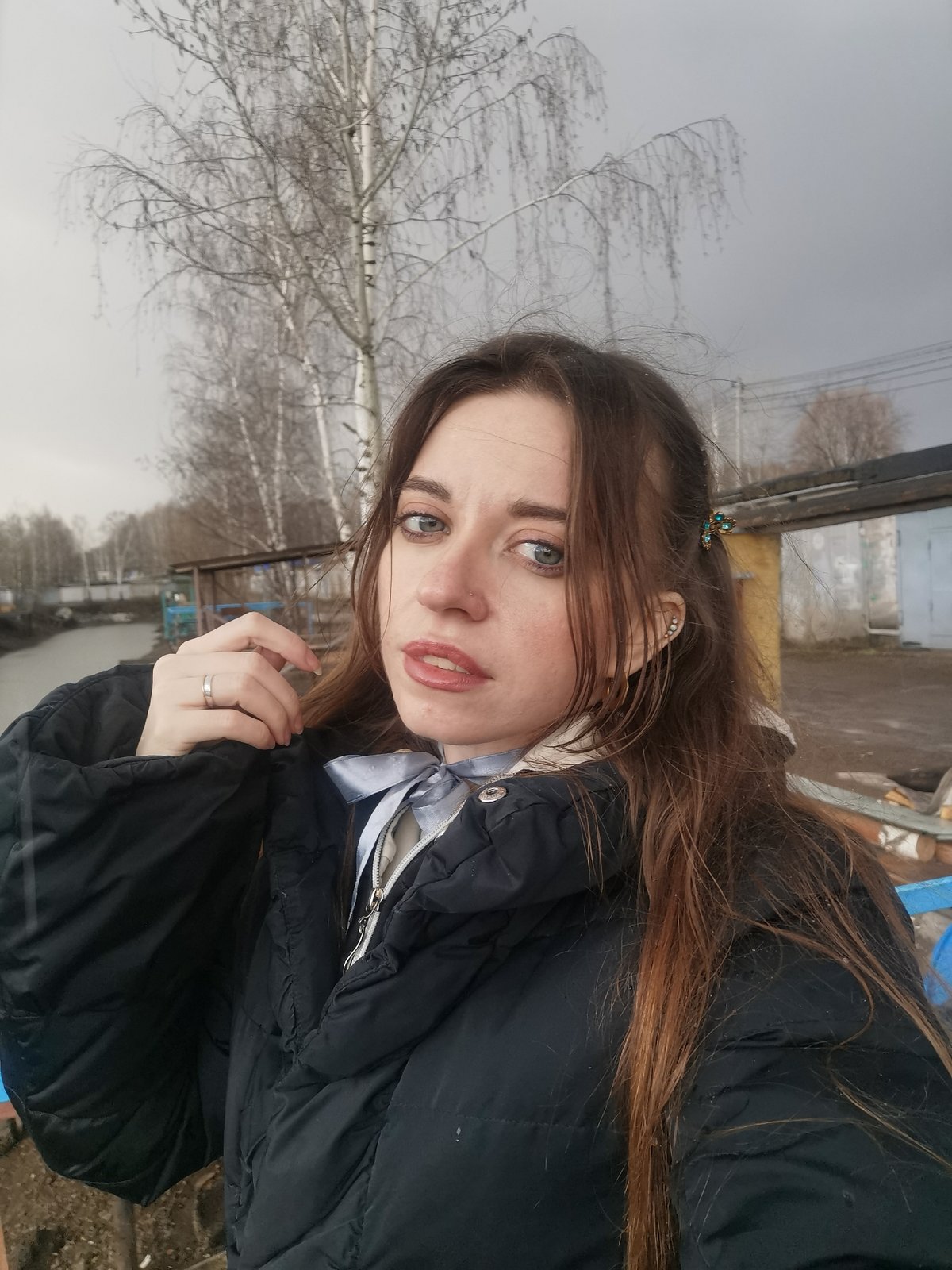 Woman documents rainy waterfront visit with selfies, duck sightings